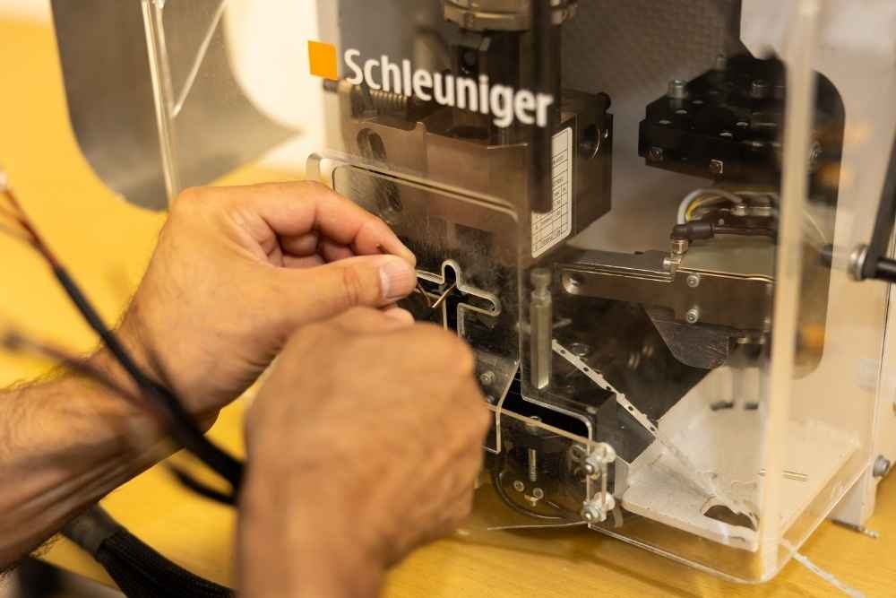 Technician operating automated wire processing equipment at Tec-Stop