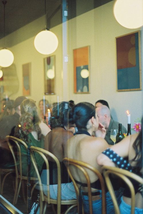 A candlelit table filled with friends sharing a meal