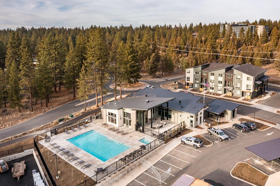 An aerial view of an apartment complex with a swimming pool.