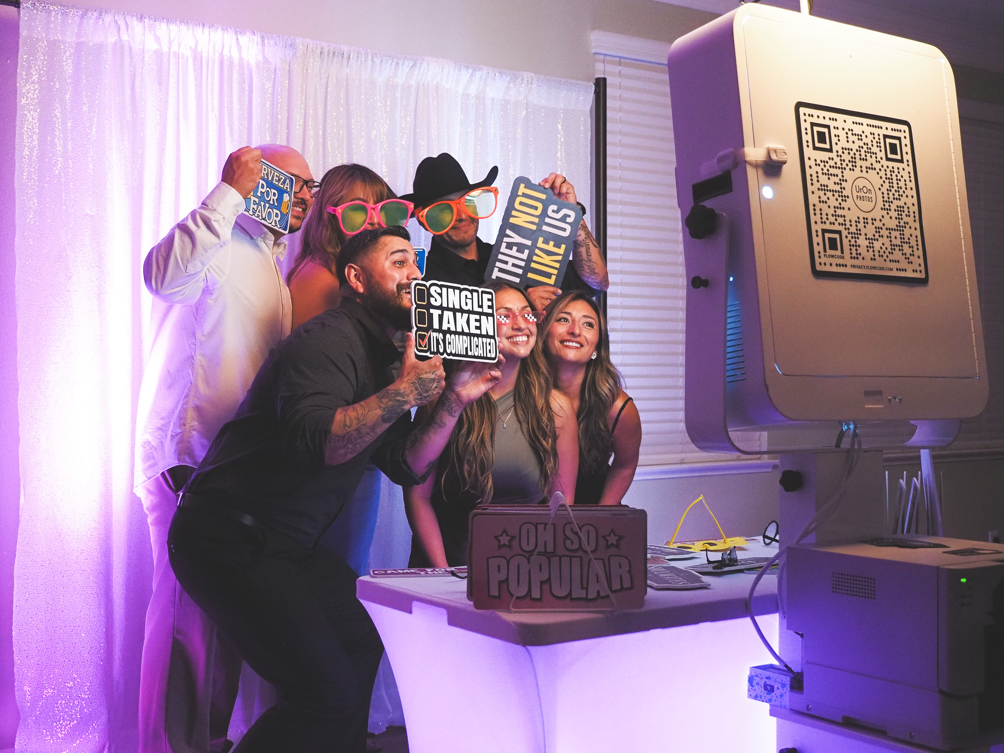 Guests posing with props at the UrOn Photos booth during an event