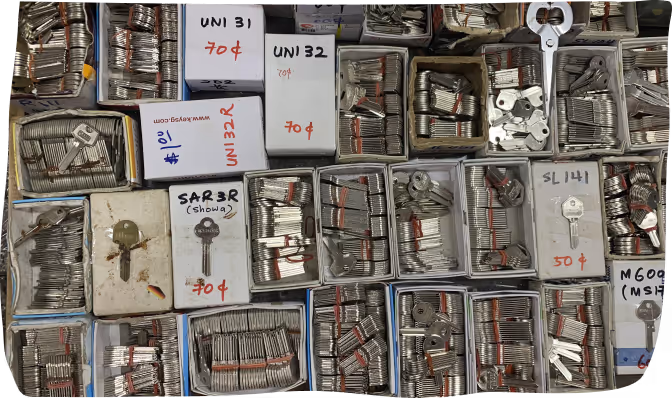 Boxes filled with various metal keys organized and labeled with prices and codes.