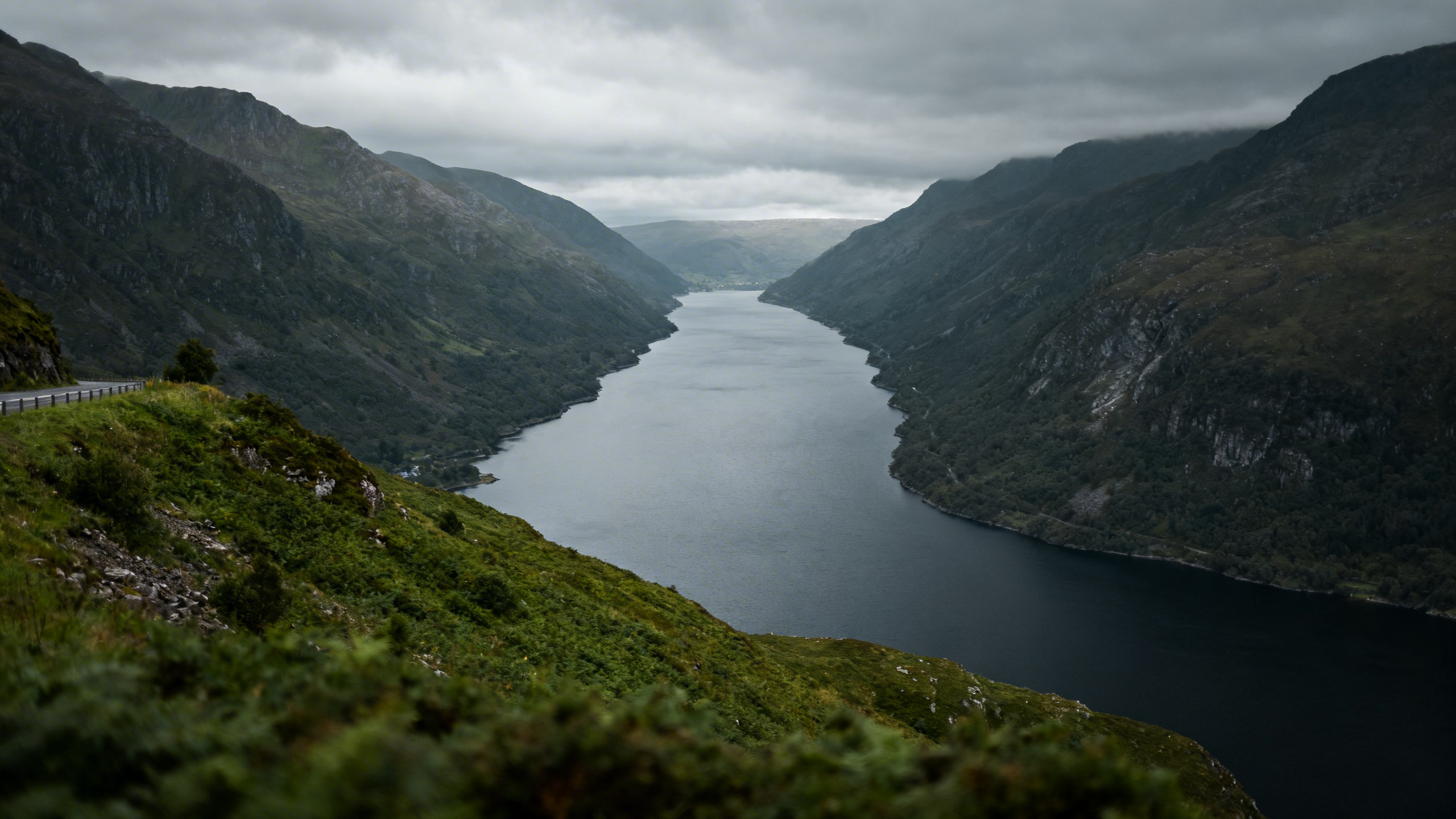 Killary Harbour from the road above Leenane, the long narrow fjord-like inlet between steep mountain slopes, still dark water, grey sky