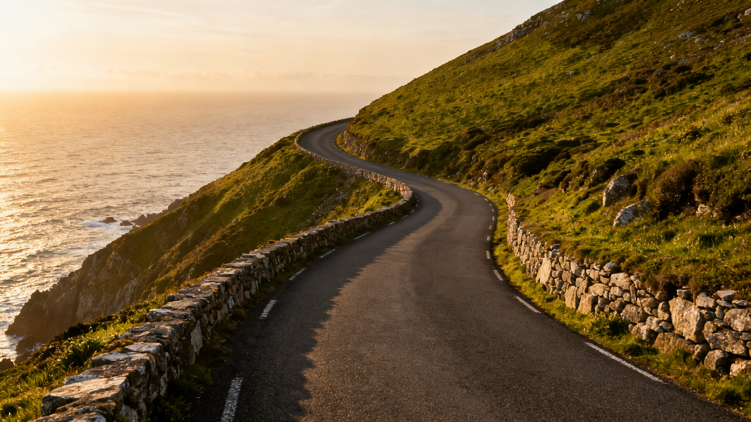 The Ring of Kerry coastal road curving along dramatic sea cliffs above the Atlantic on a clear summer day