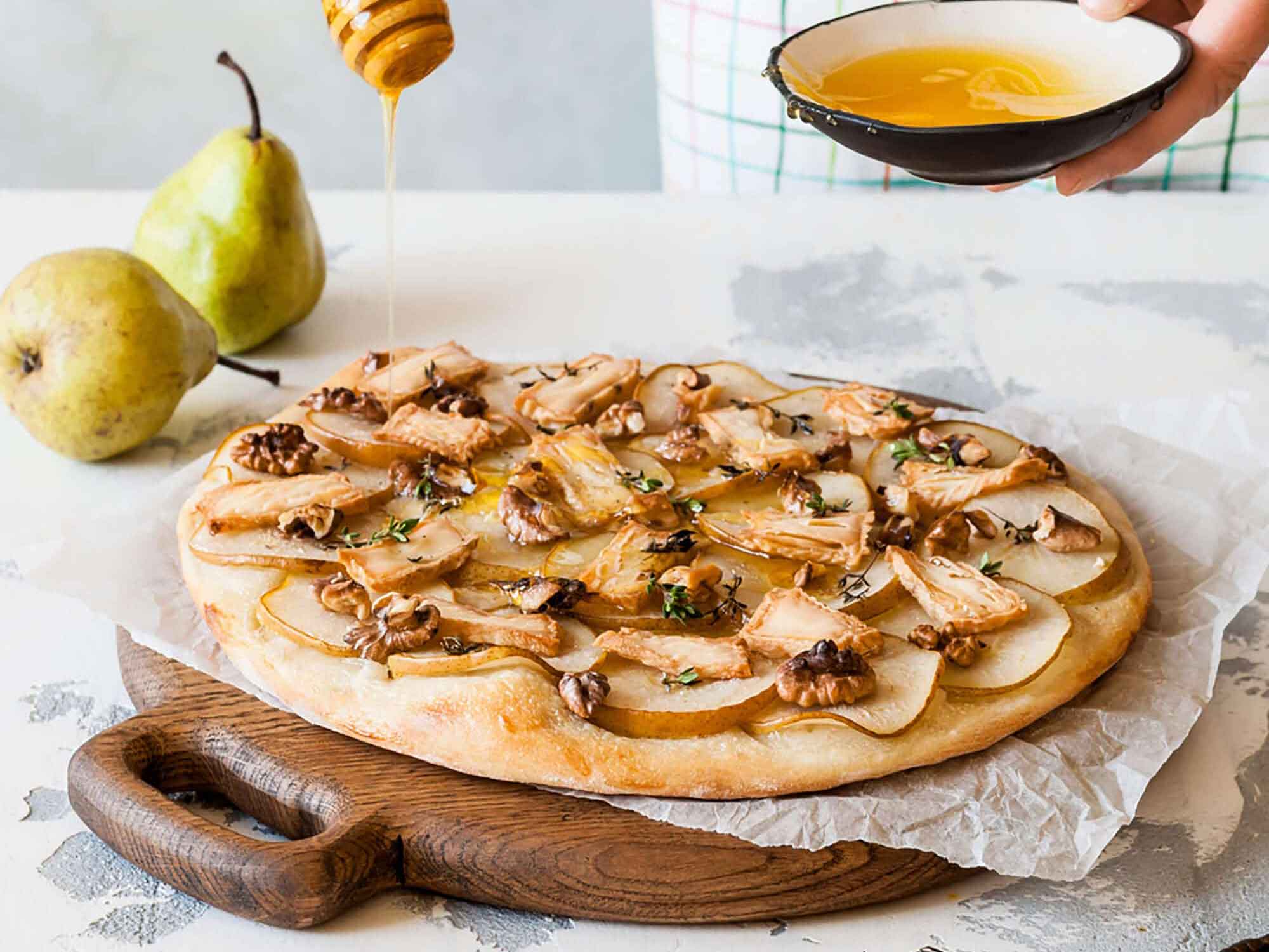 Valmista herkullinen päärynä pizza saksanpähkinöillä ja sinihomejuustolla. Karamellisoitu makuelämys, kokeile nyt!