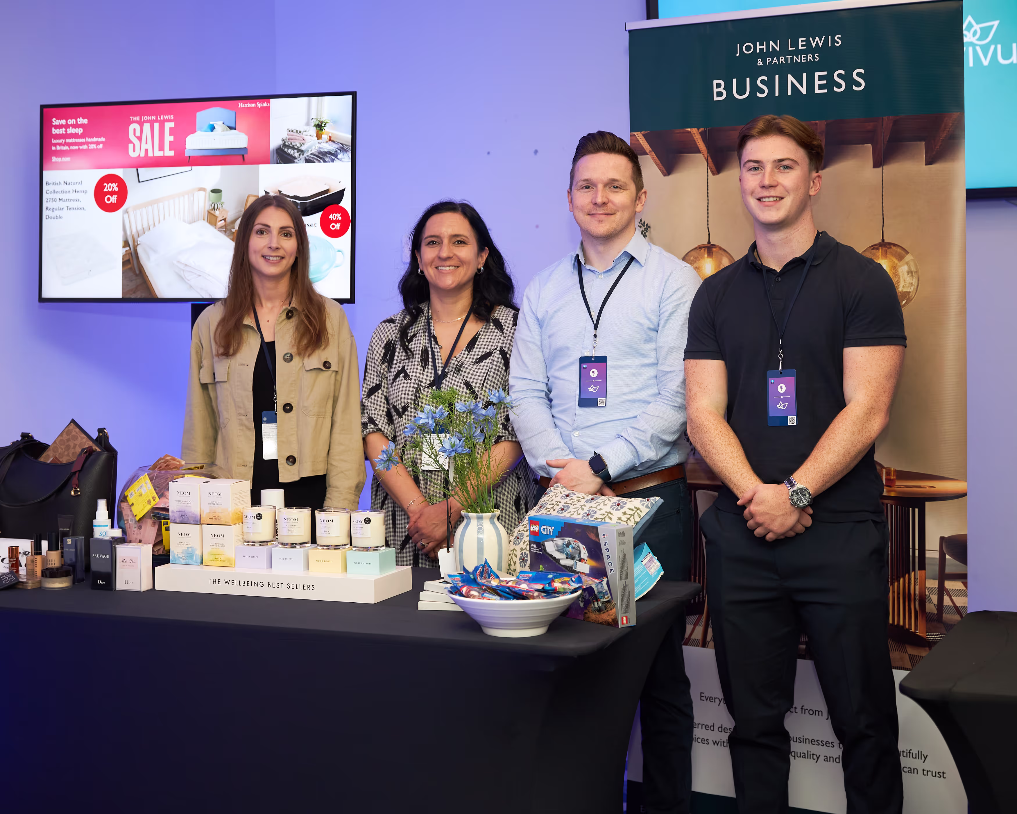 Group of employees standing together at an exhibition stand, engaging with visitors and showcasing their company or products.