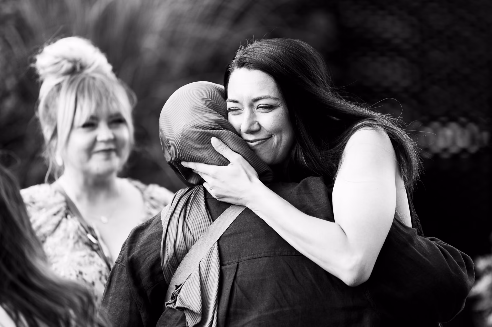 Two colleagues embracing warmly as they greet each other at a company celebration