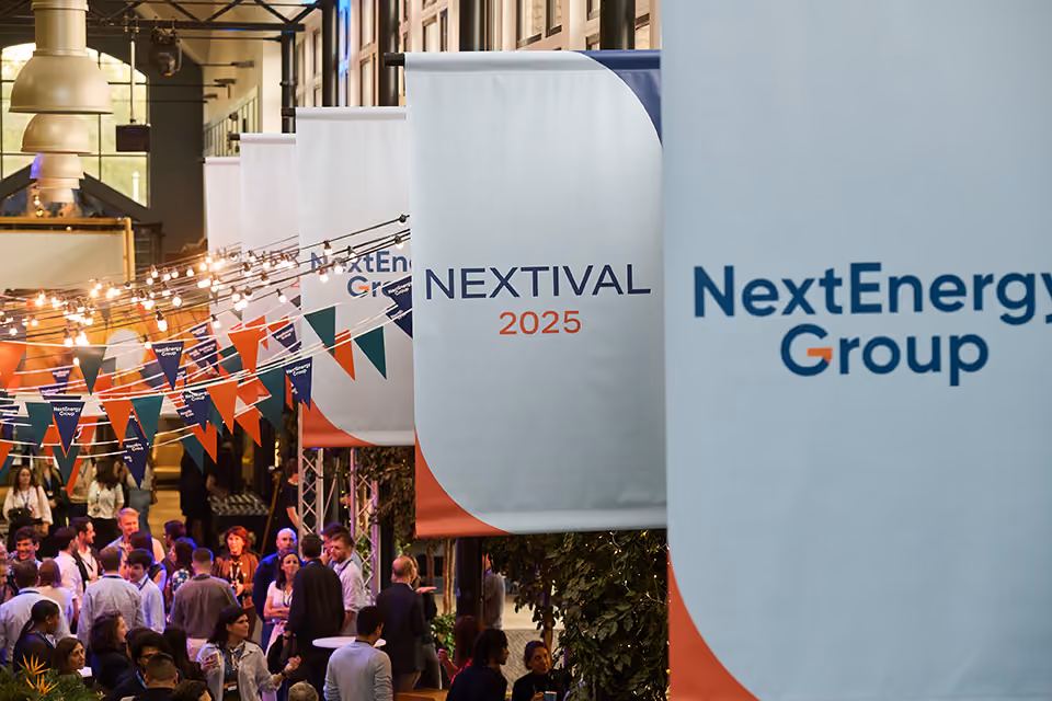 Branded banners above guests mingling under bunting and festoon lights at Nextival 2025
