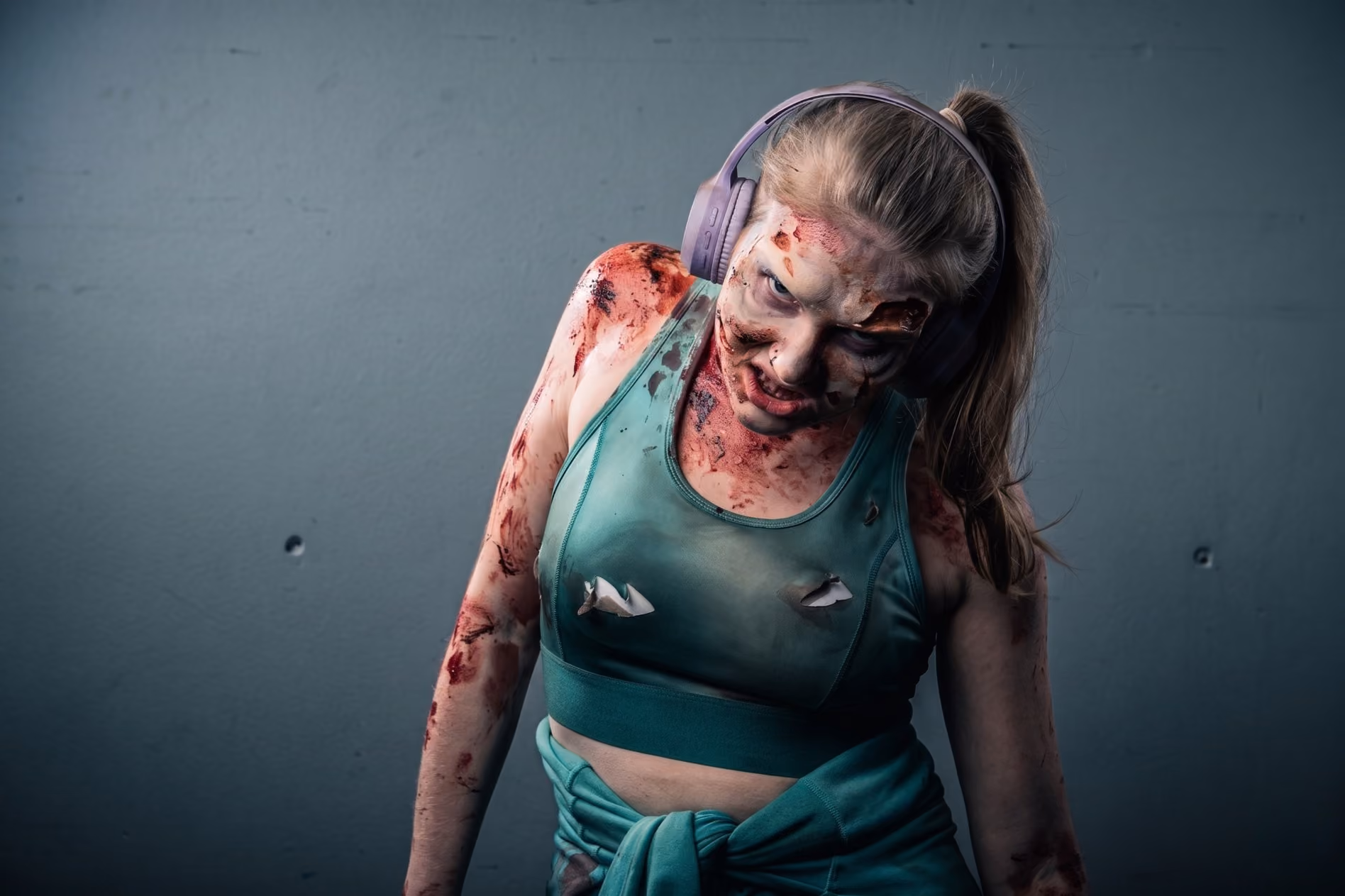 Performer in zombie makeup and torn sportswear at the Dead Island 2 launch event