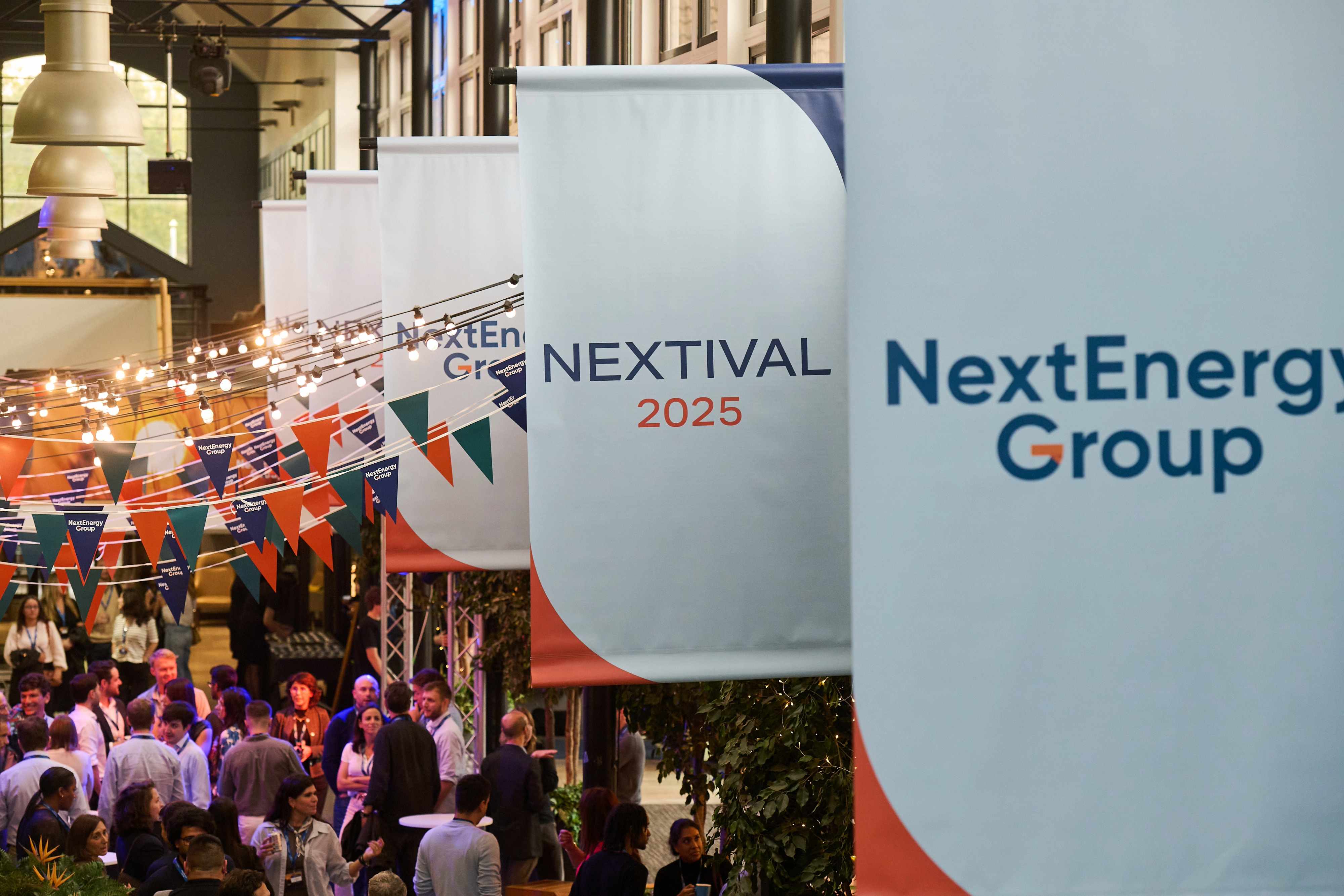 Branded festival banners and bunting hanging above a crowd at a company away day