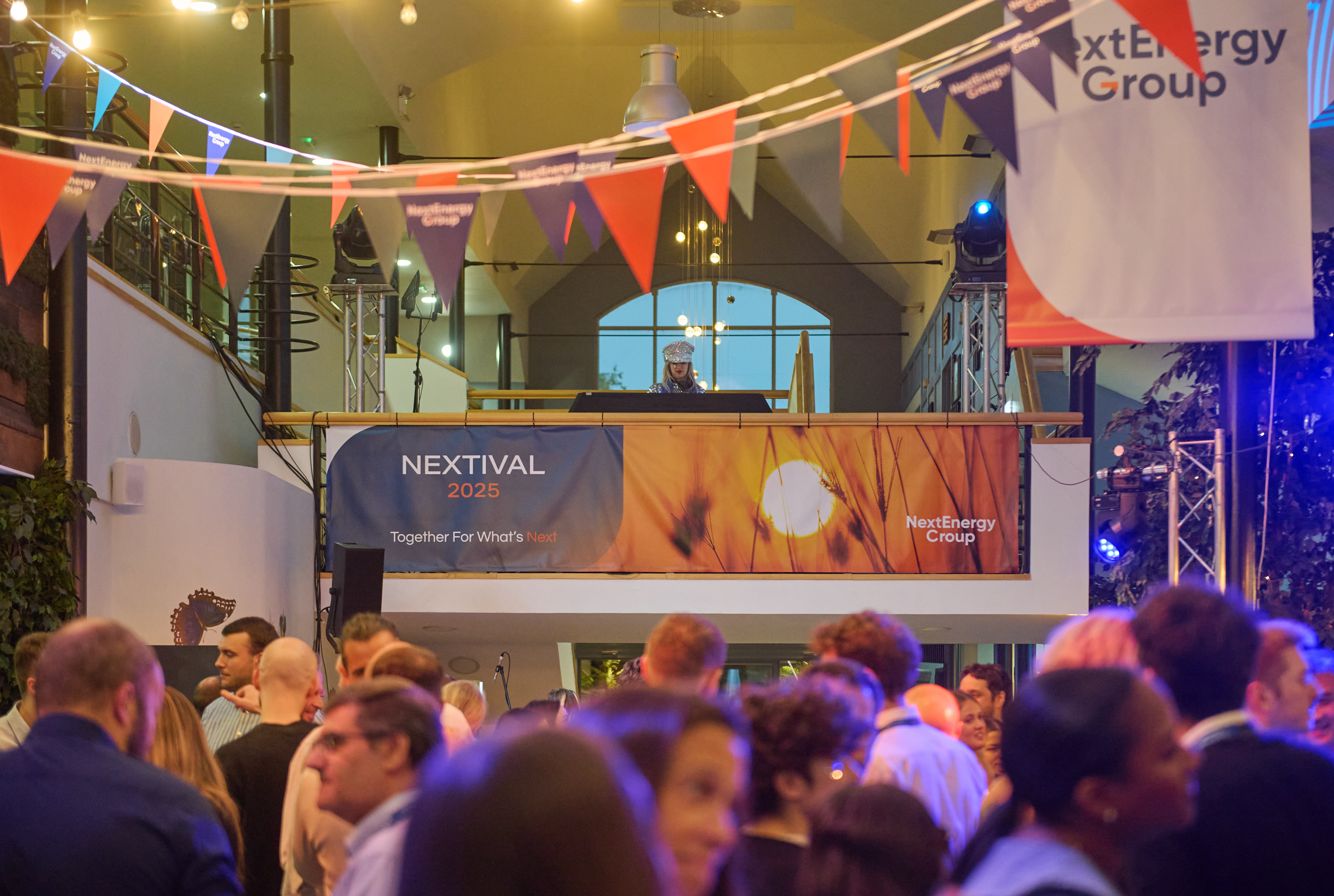 A crowd gathered below a mezzanine stage during a festival themed away day