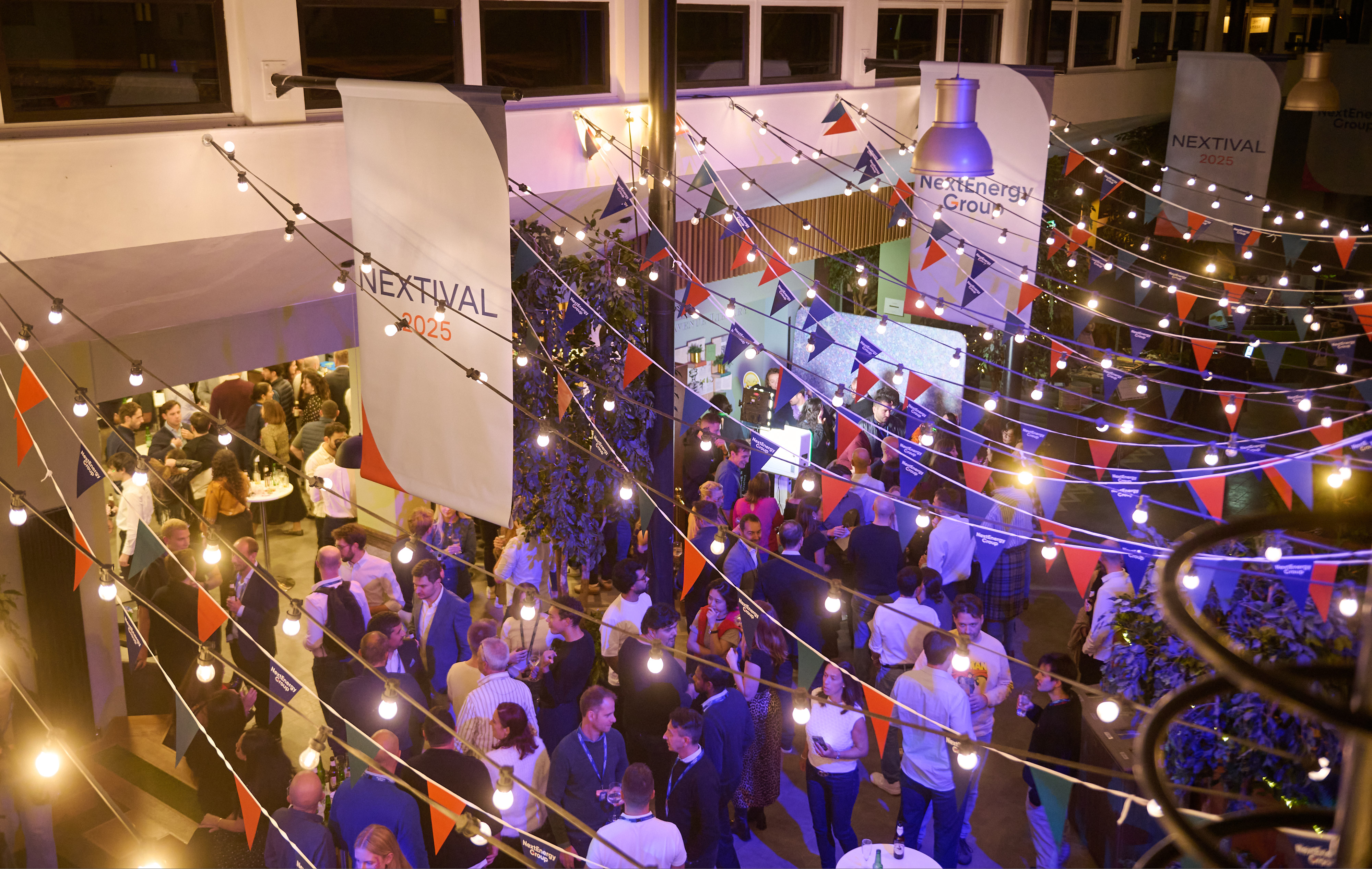 Guests filling a lit courtyard beneath festival banners and strings of bulbs