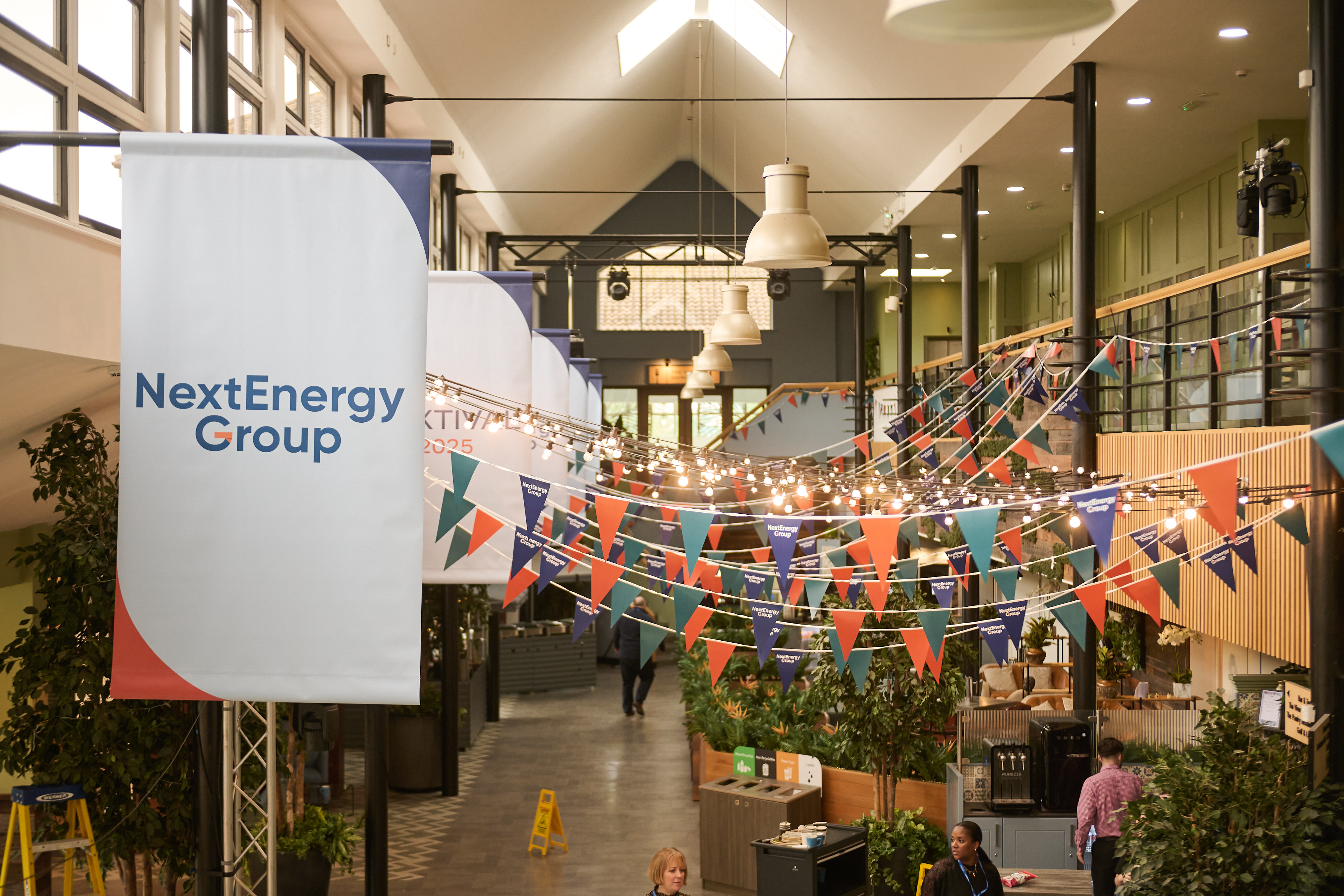 A company banner and bunting strung across a bright open-plan office atrium