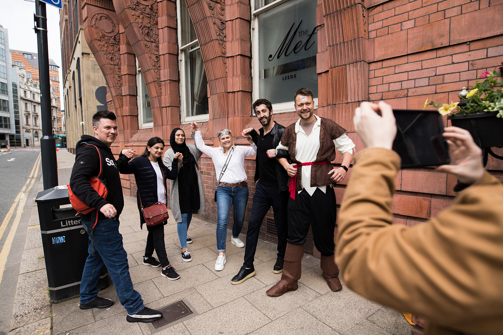 Colleagues posing with costumed guides on a city street during a team challenge