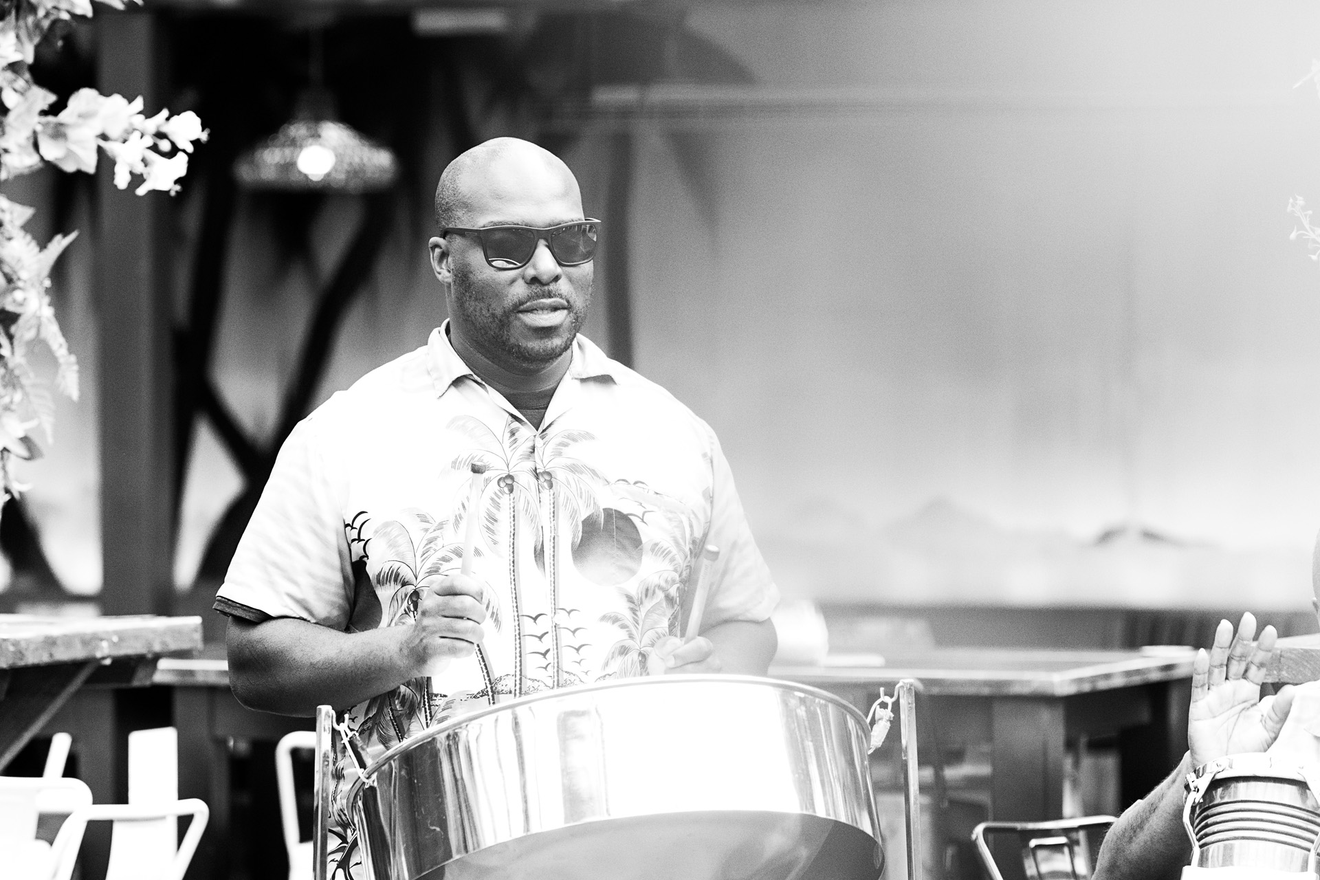 A black and white shot of a steel pan player performing for guests
