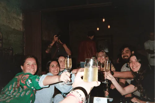 Team toasting with champagne around a dinner table at an Offsiteio offsite