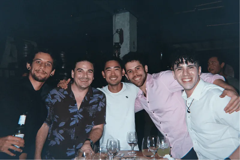 Teammates posing arm in arm after dinner at an Offsiteio offsite