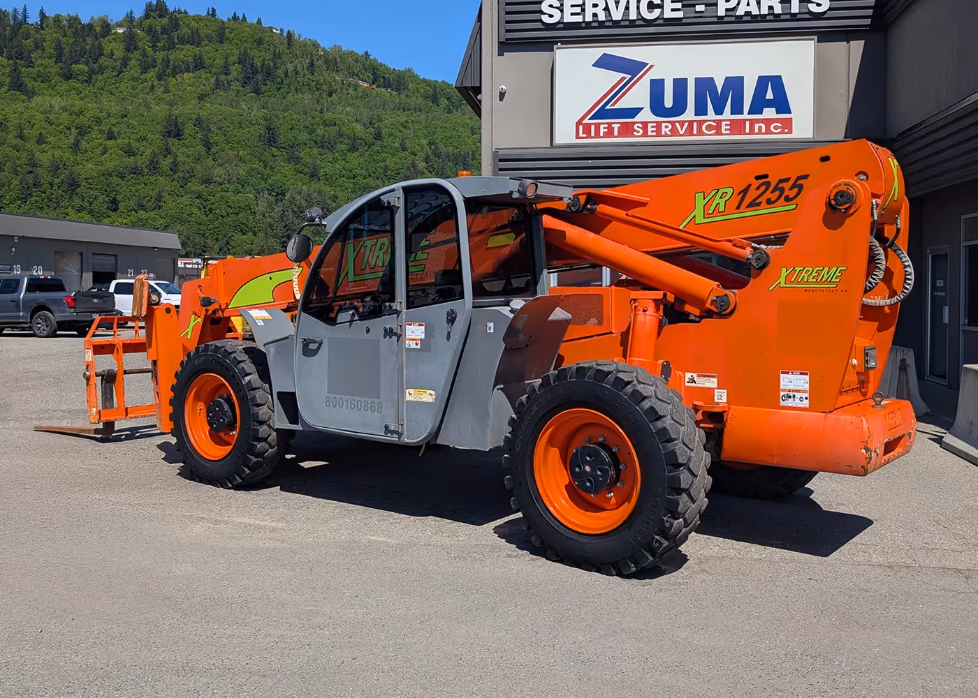 Rear-quarter view of orange 2017 Xtreme XR1255 Telehandler with enclosed cab | Xtreme XR1255