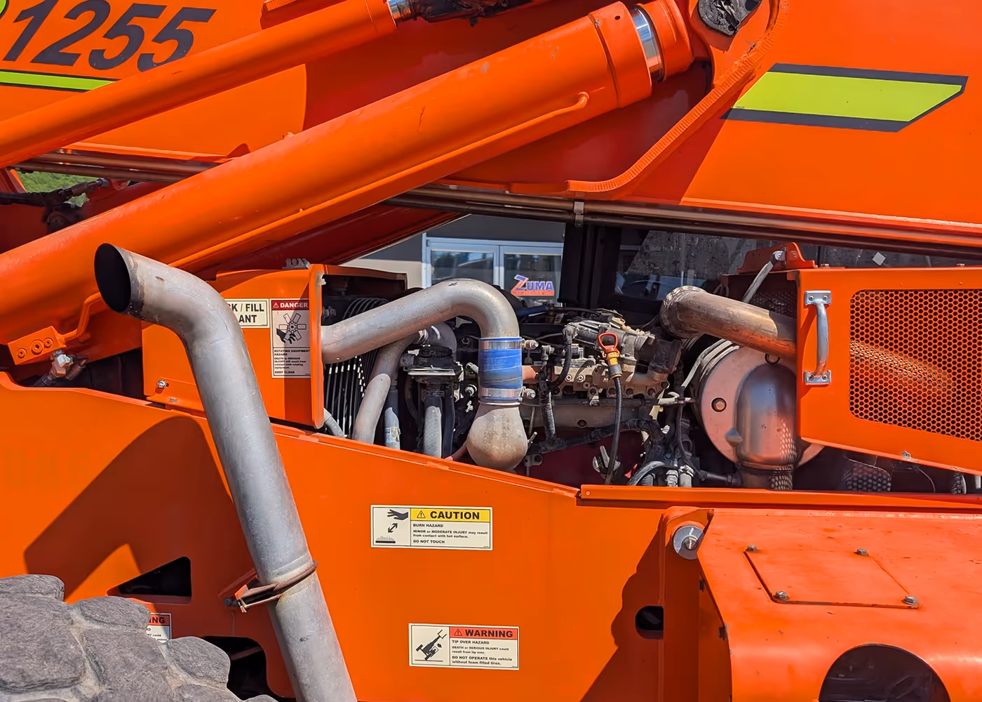 Engine compartment of orange 2017 Xtreme XR1255 Telehandler showing motor and exhaust | machinery engine