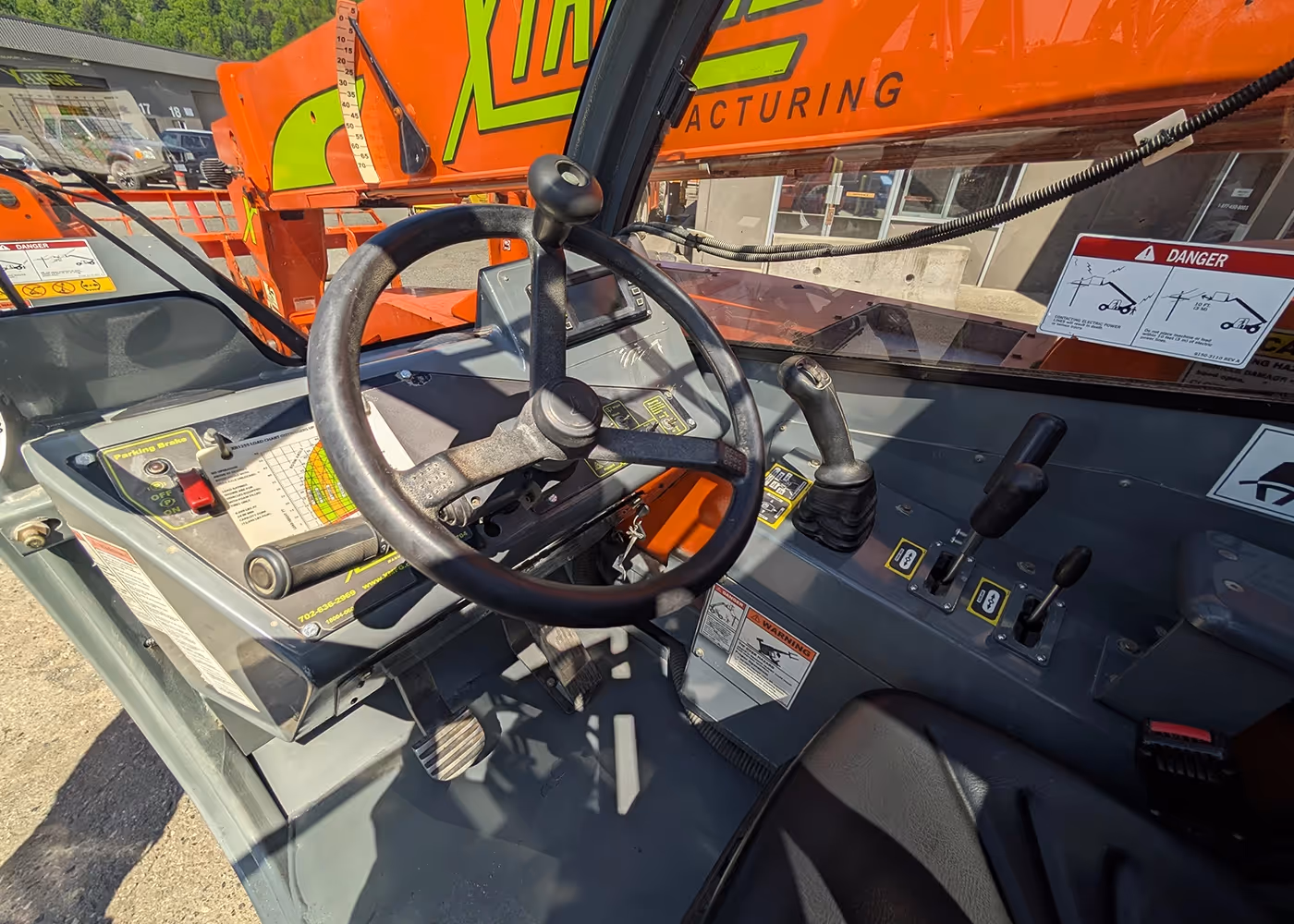 Steering wheel and control levers inside the cab of 2017 Xtreme XR1255 Telehandler | operator controls