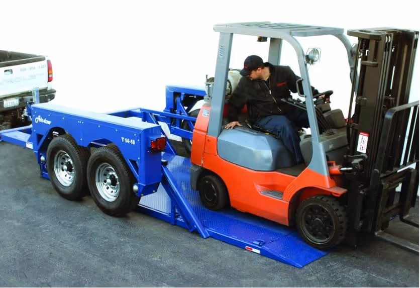 An orange forklift loading onto a blue Air-Tow T14-10 Utility drop deck trailer, demonstrating the ground-level loading feature.