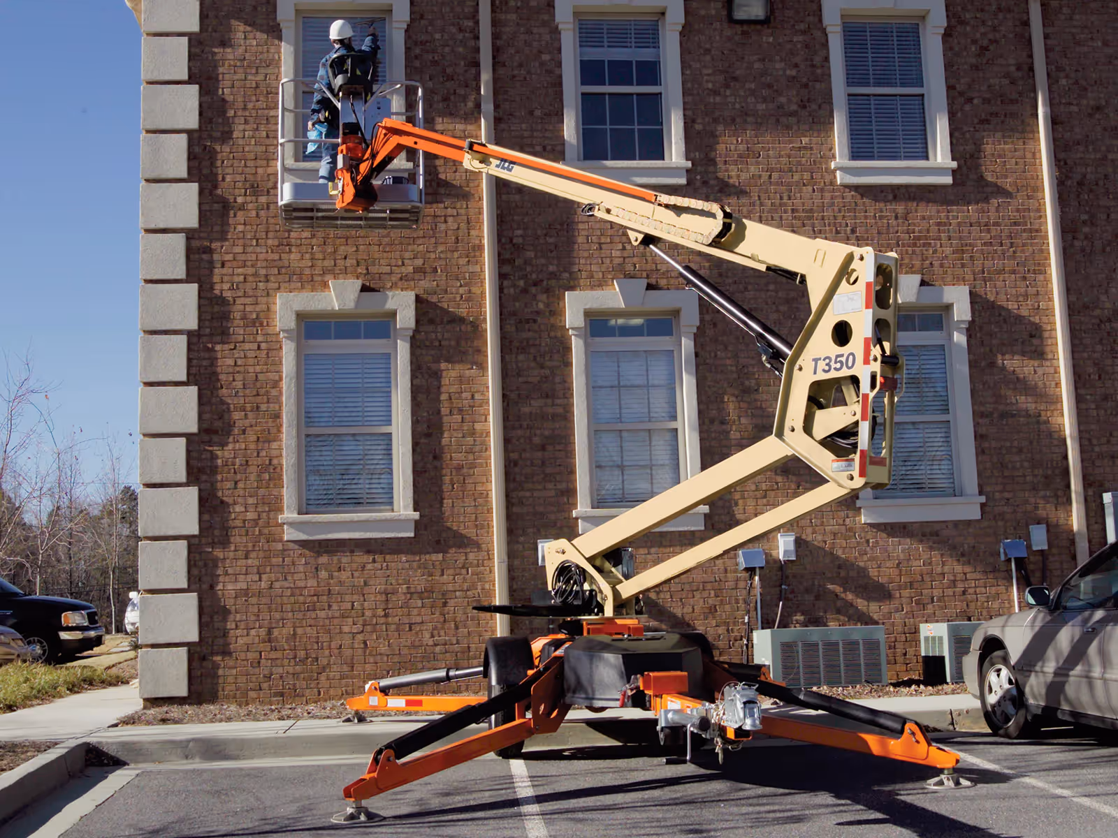 JLG T350 elevated for exterior maintenance on multi-story building in Canada