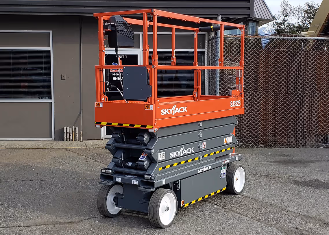 Skyjack SJ3226 scissor lift angled view near facility entrance in Canada