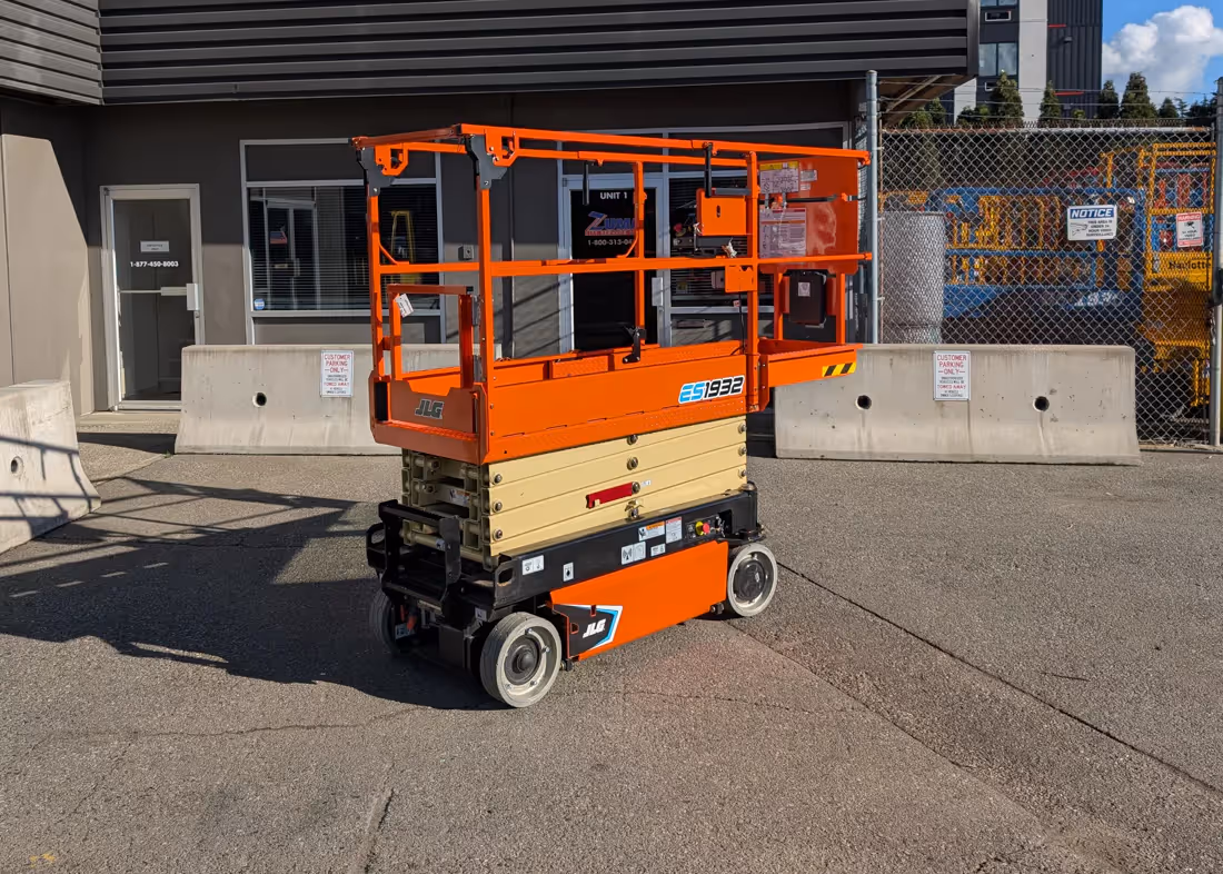 JLG ES1932 electric scissor lift with its platform extension deployed outdoors on pavement