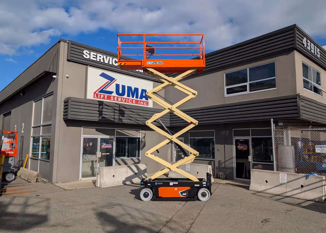 JLG ES2632 lift fully raised in front of building exterior in Canada