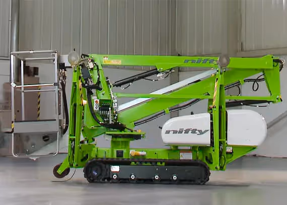 Niftylift TD34T track boom lift side view in stowed position inside a facility.