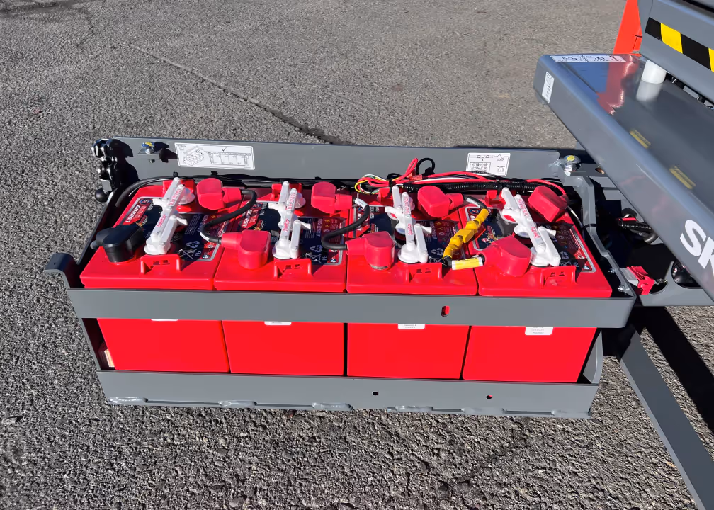 Skyjack SJ3219 E battery pack tray showing red deep cycle batteries in Canada