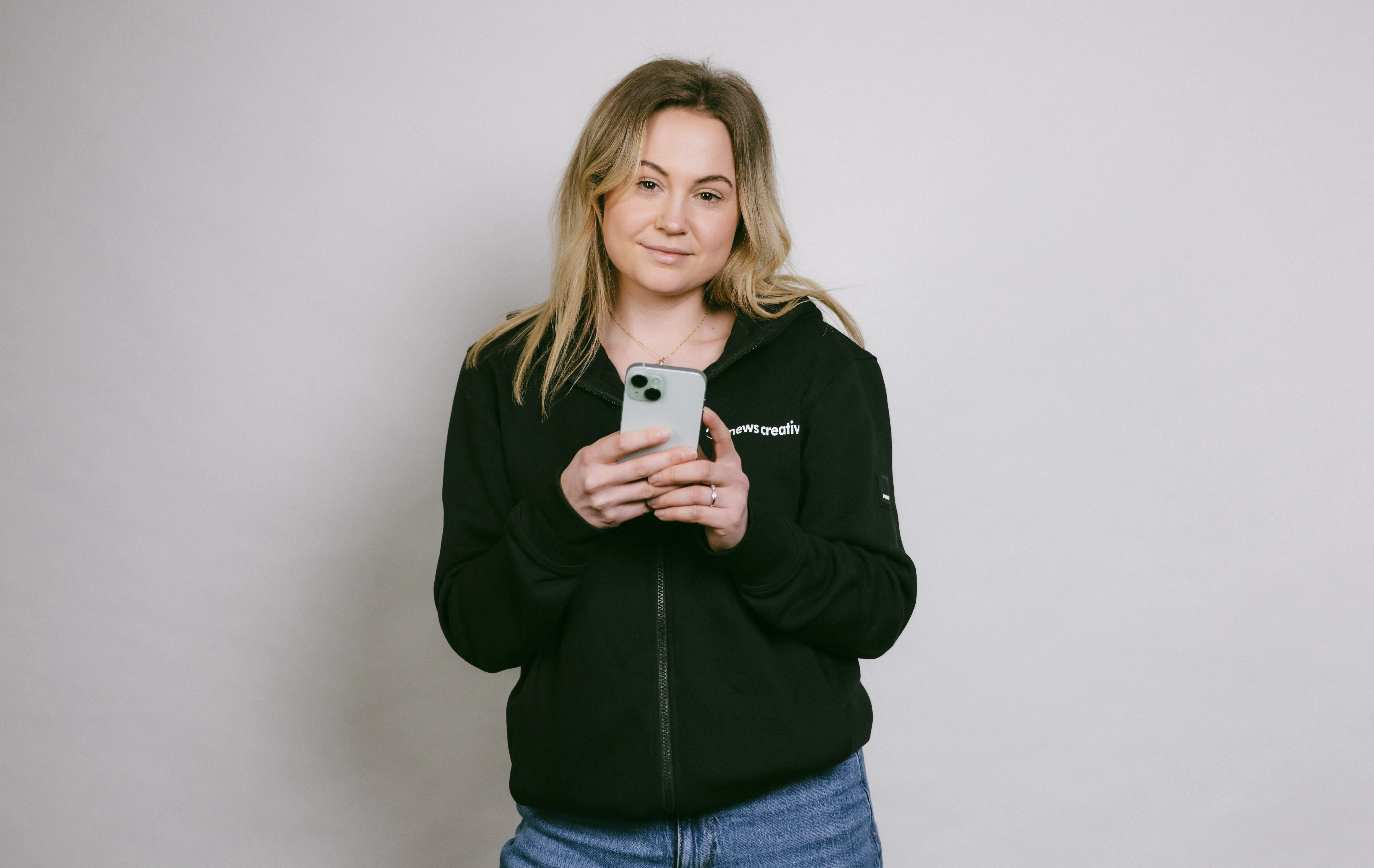 Clarissa mit grünem IPhone 15
