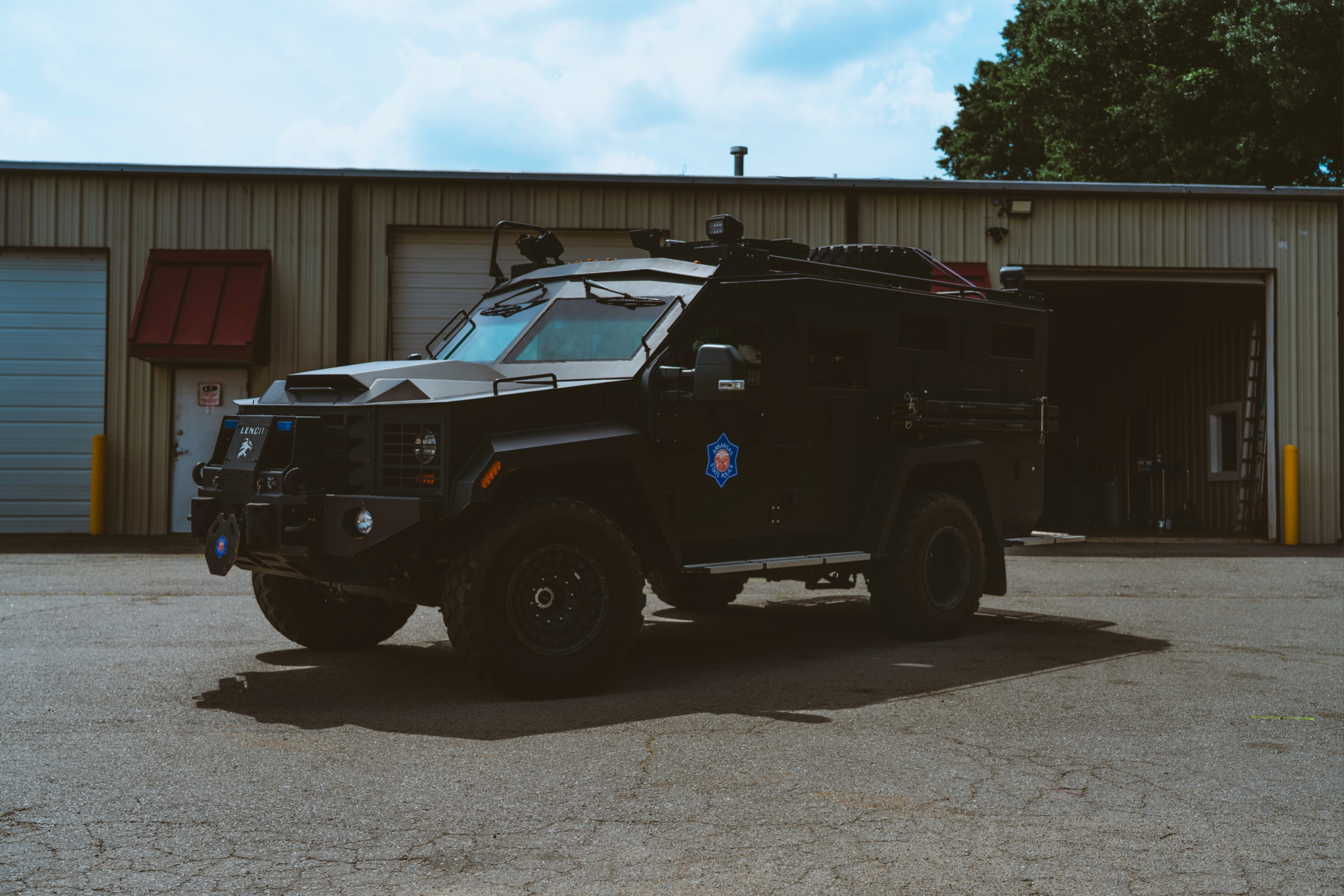 Officers loading ballistic vests from a patrol vehicle