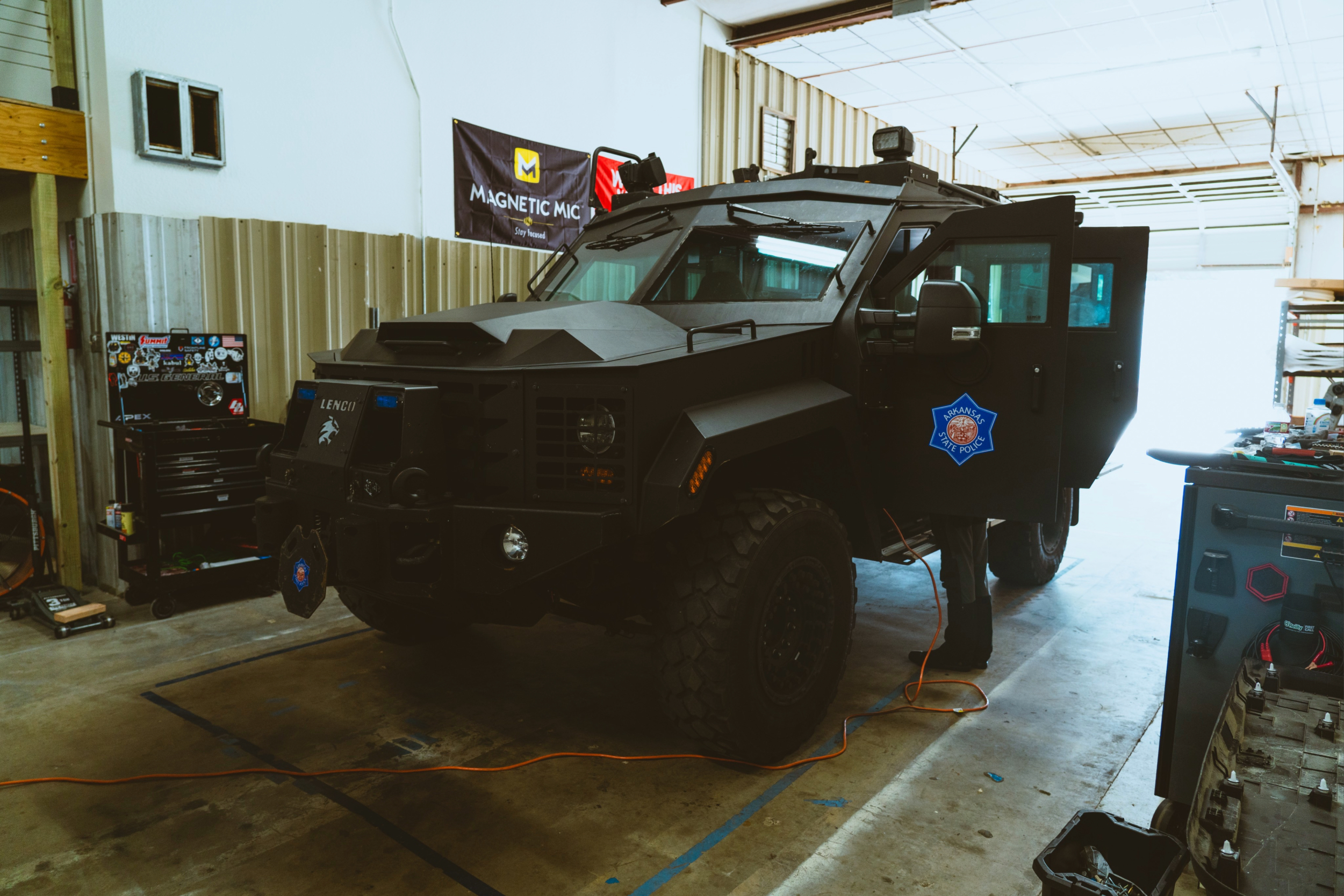 Officers loading ballistic vests from a patrol vehicle