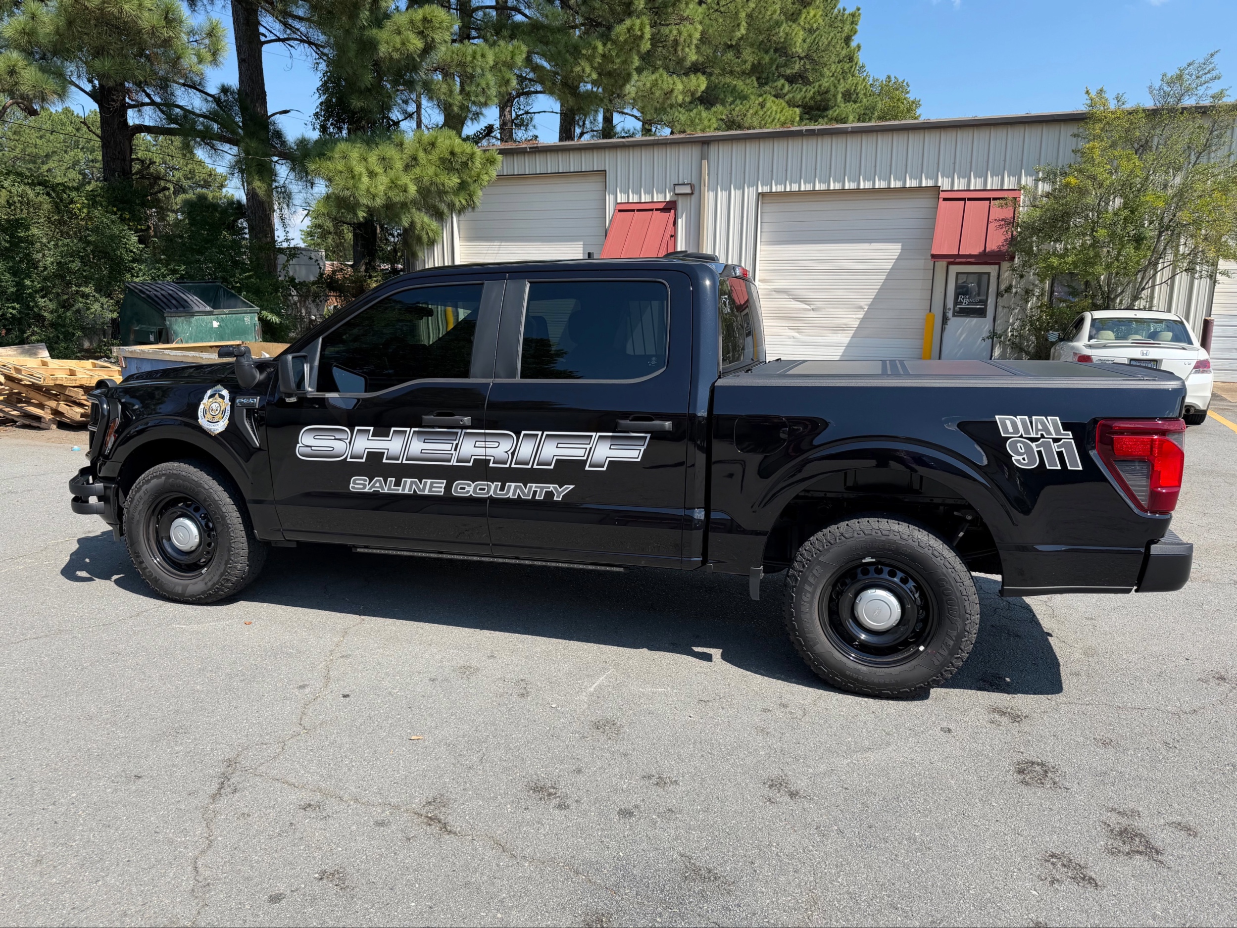 Officers loading ballistic vests from a patrol vehicle