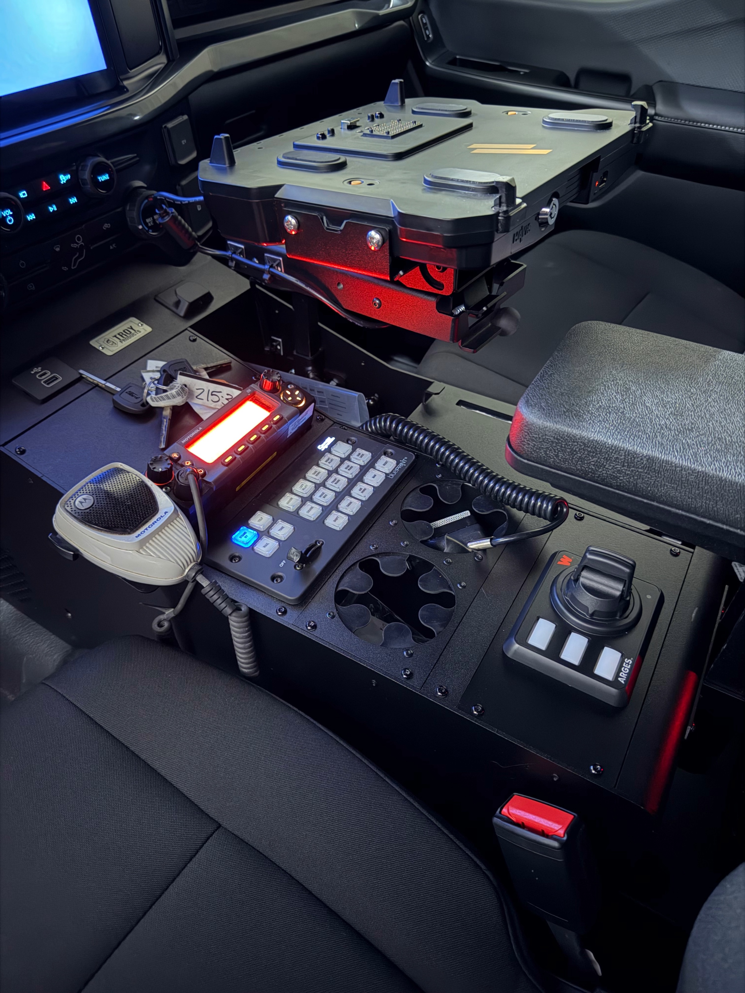 Officers loading ballistic vests from a patrol vehicle