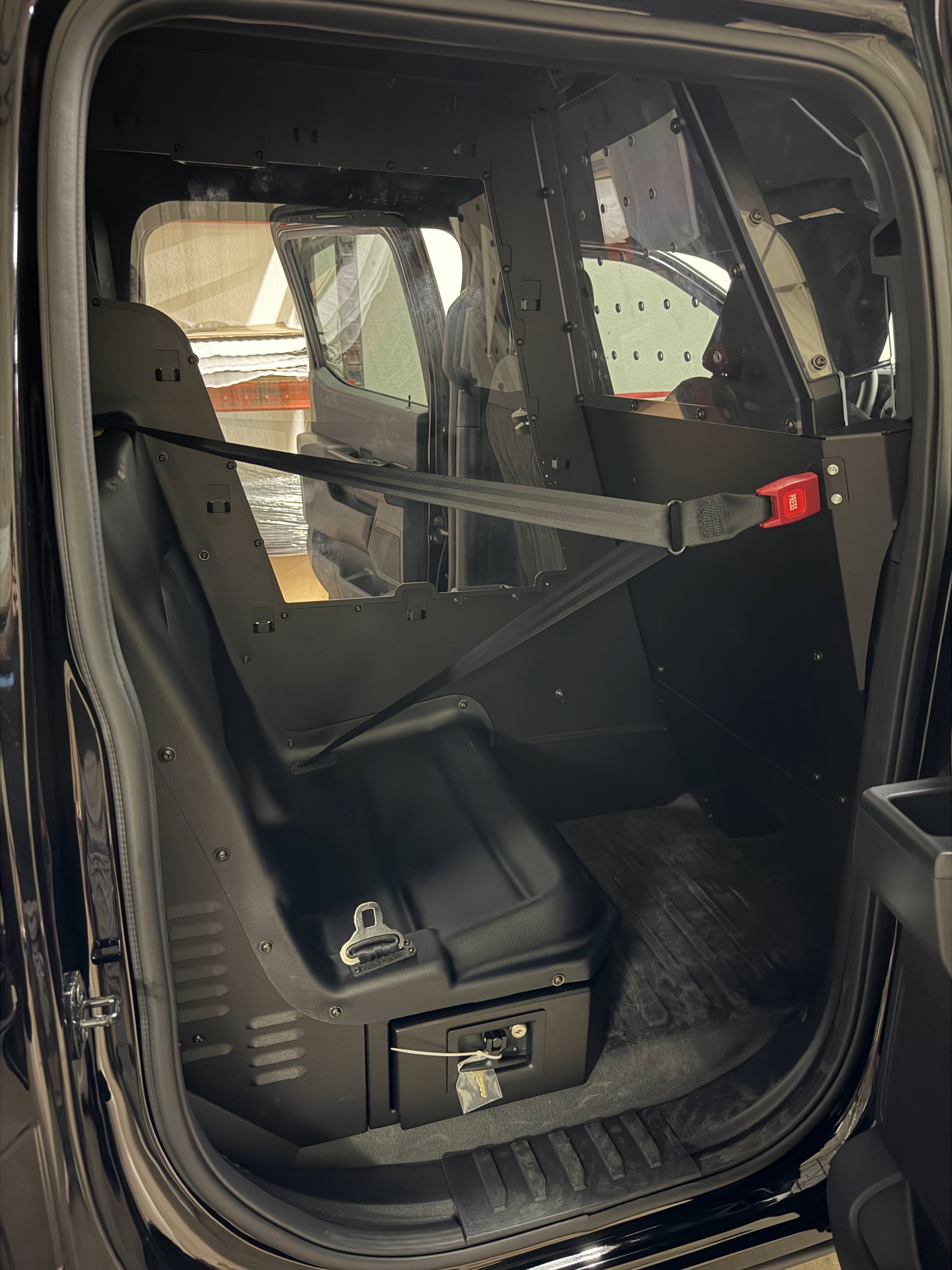 Officers loading ballistic vests from a patrol vehicle
