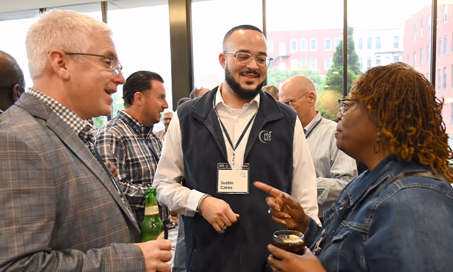 Group of business professionals smile and chat at a networking event