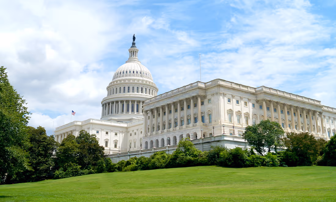 US Capital building with green lawn and blue sky 