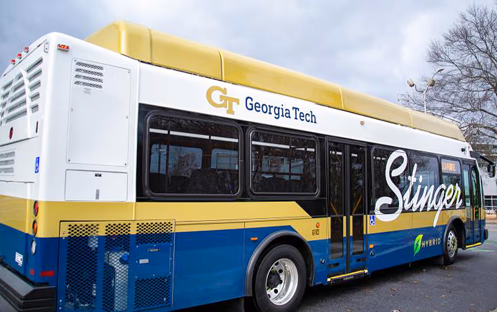 university electric transit bus with gold and blue school logo