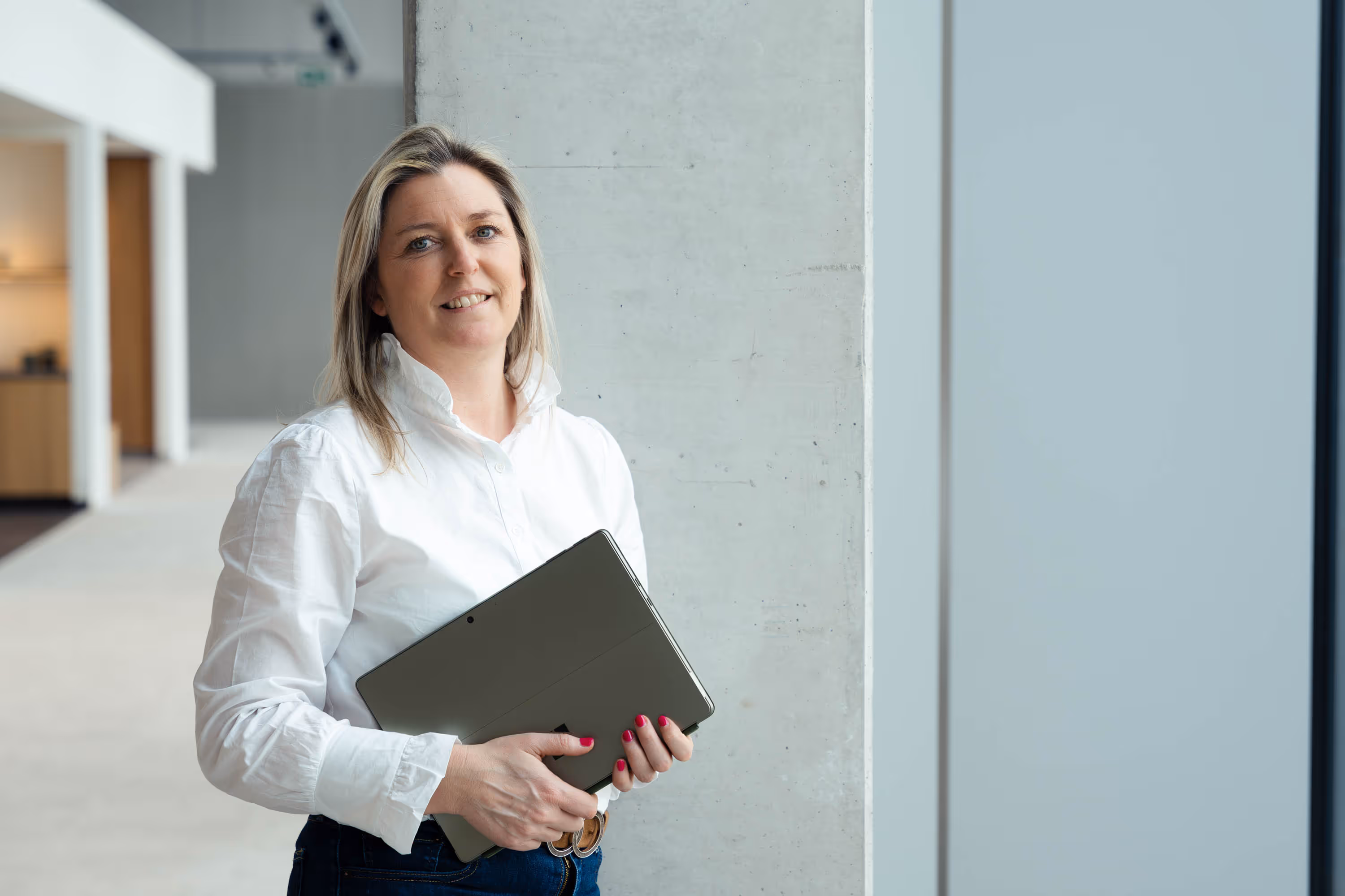 Lady holding a laptop in white shirt