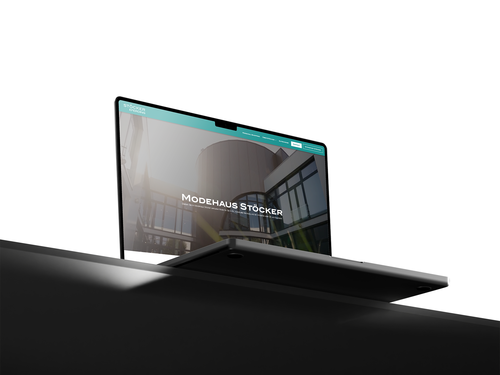 Laptop zeigt Website von Modehaus Stöcker mit modernem Gebäude und Navigation oben.