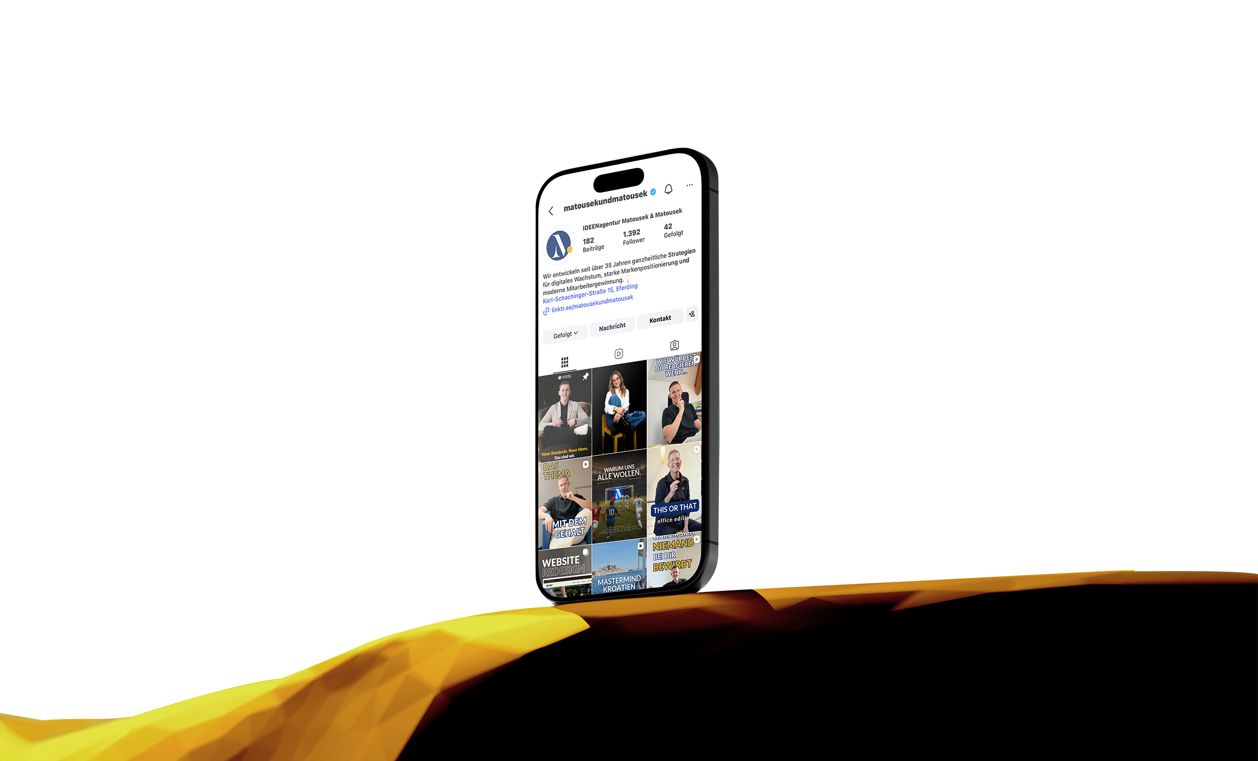 Smartphone mit geöffneter Instagram-Seite der Marketingagentur Matousek, umgeben von orange-gelben Formen.