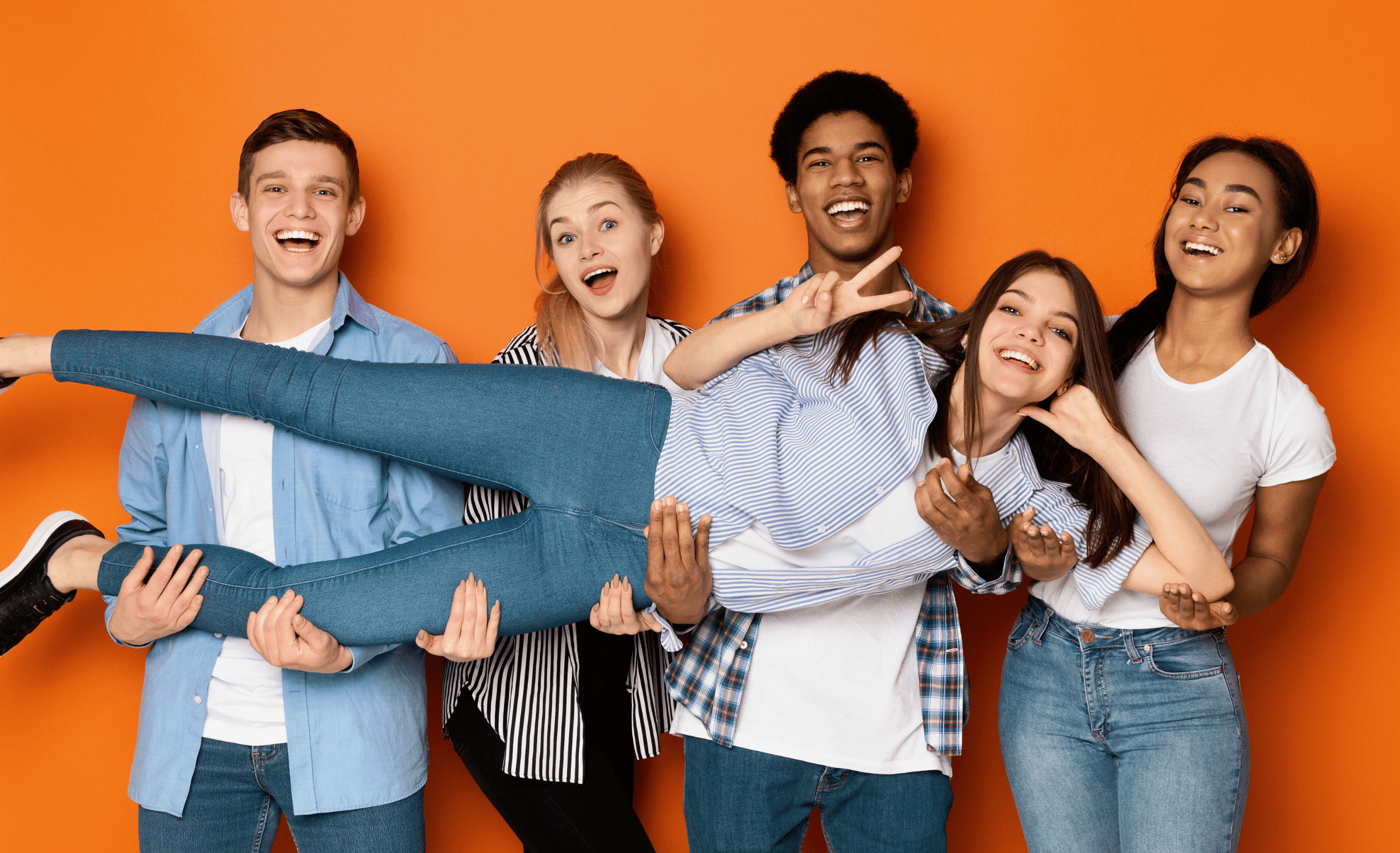 Jugendliche die lächelnd vor orangenen Hintergrund posieren