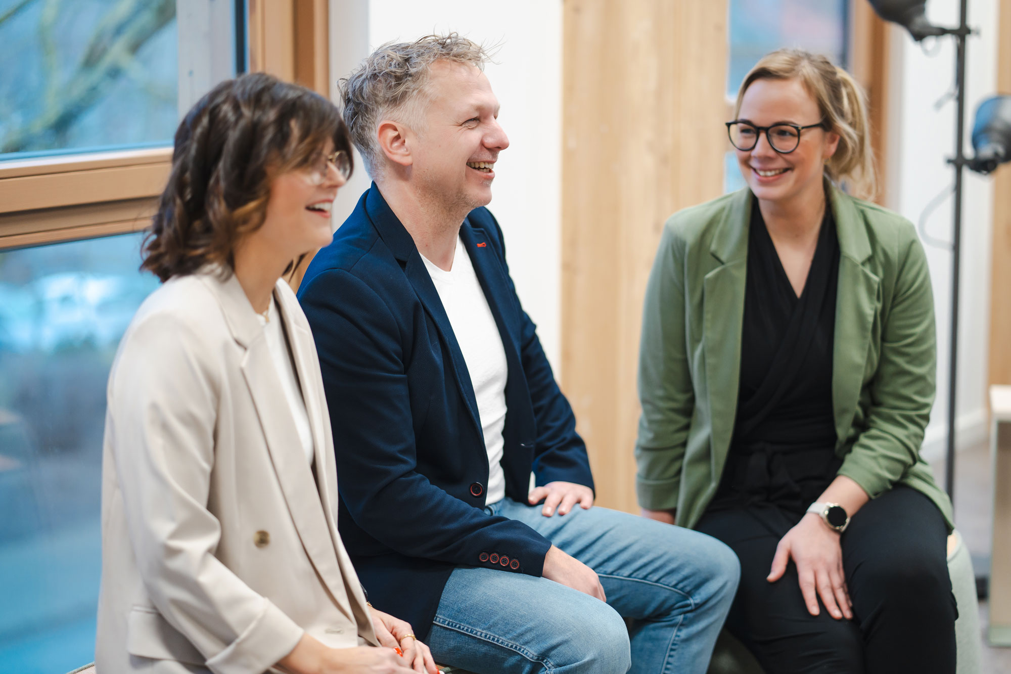 Vier Personen stehen vor einem Laptop an einem Stehtisch und besprechen etwas