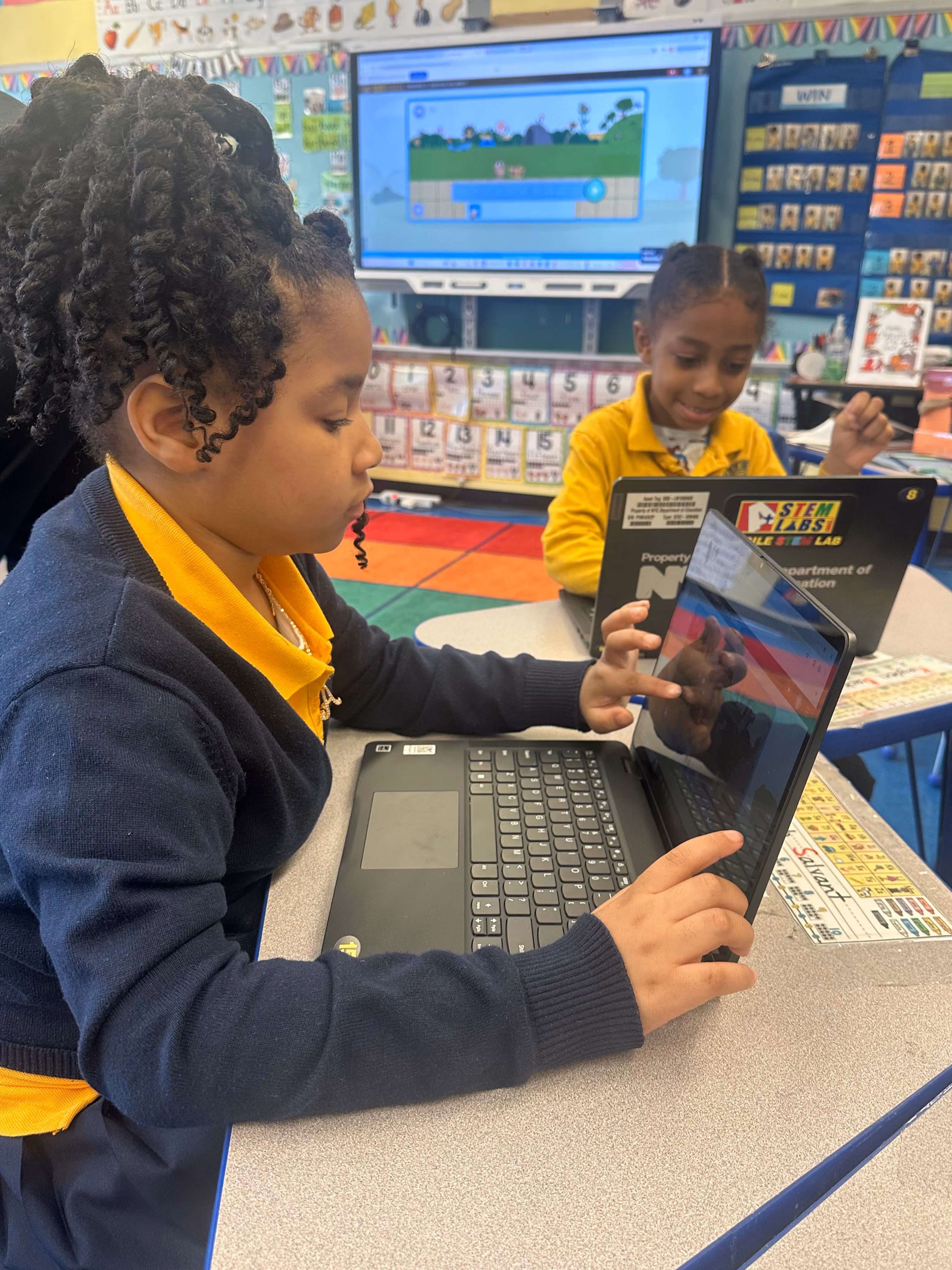 Two students using laptops during a STEM coding activity in class