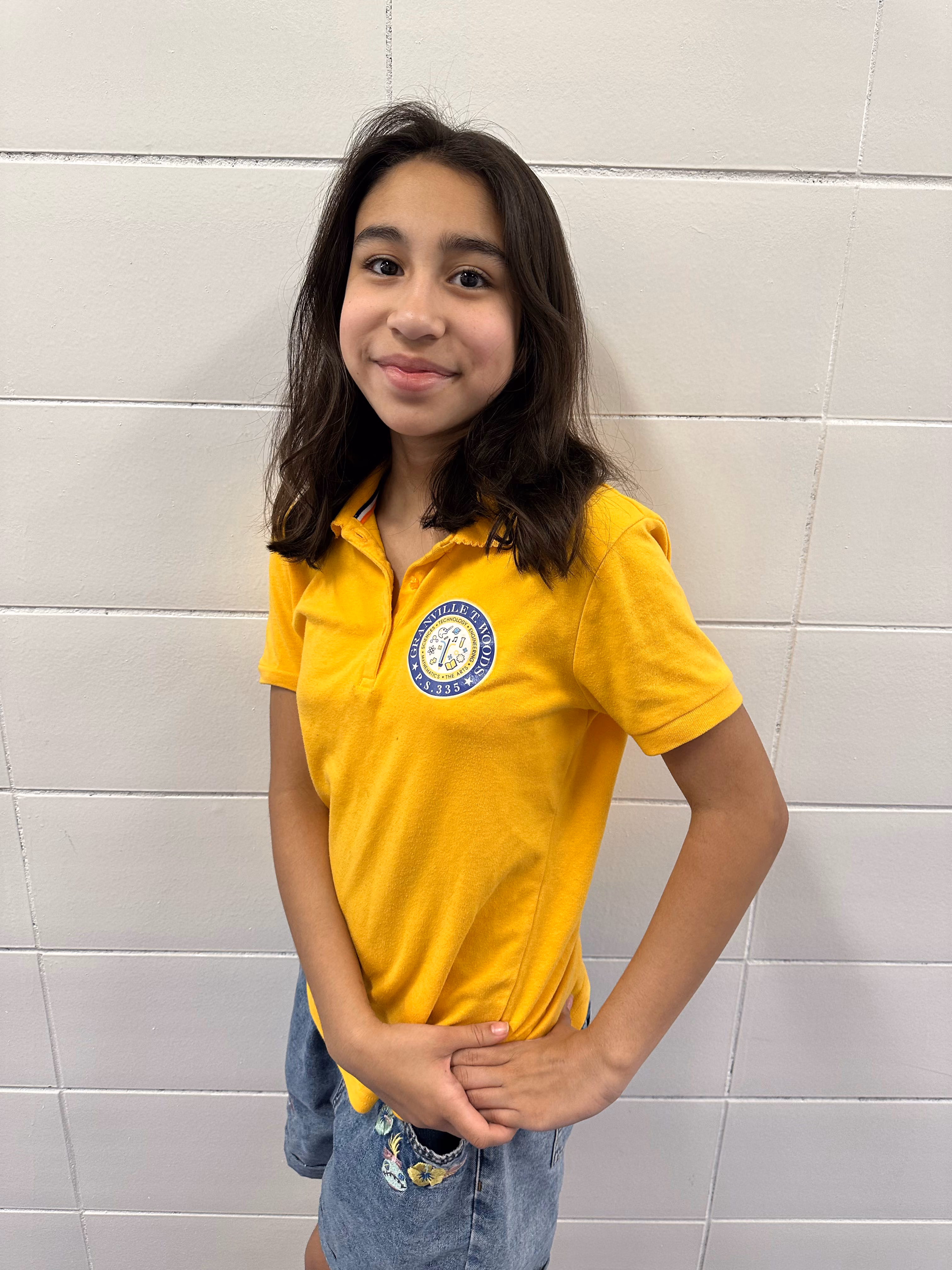 Student Kaylee M. smiling in yellow school uniform polo