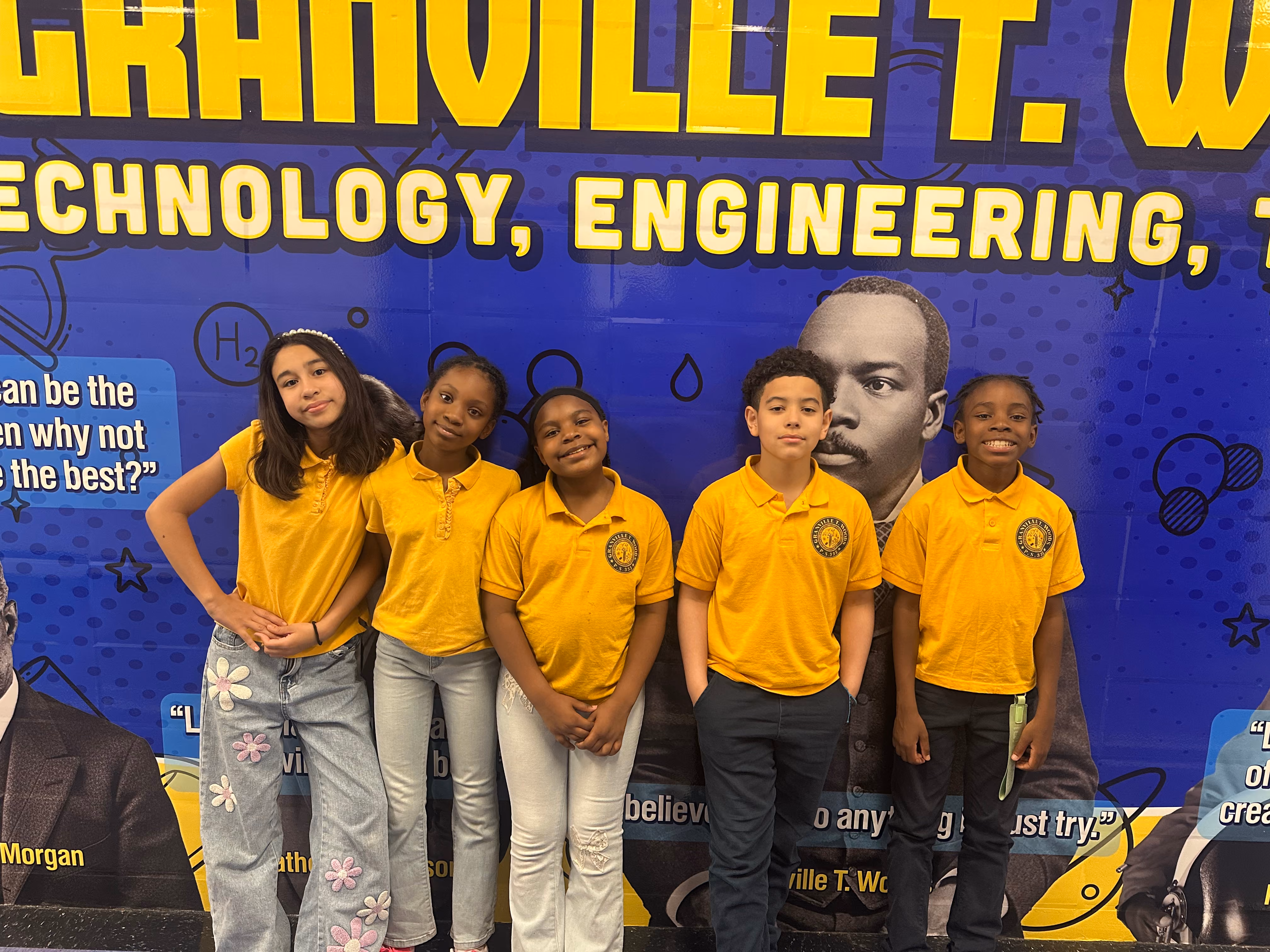 Five student council members in gold uniforms pose before school mural