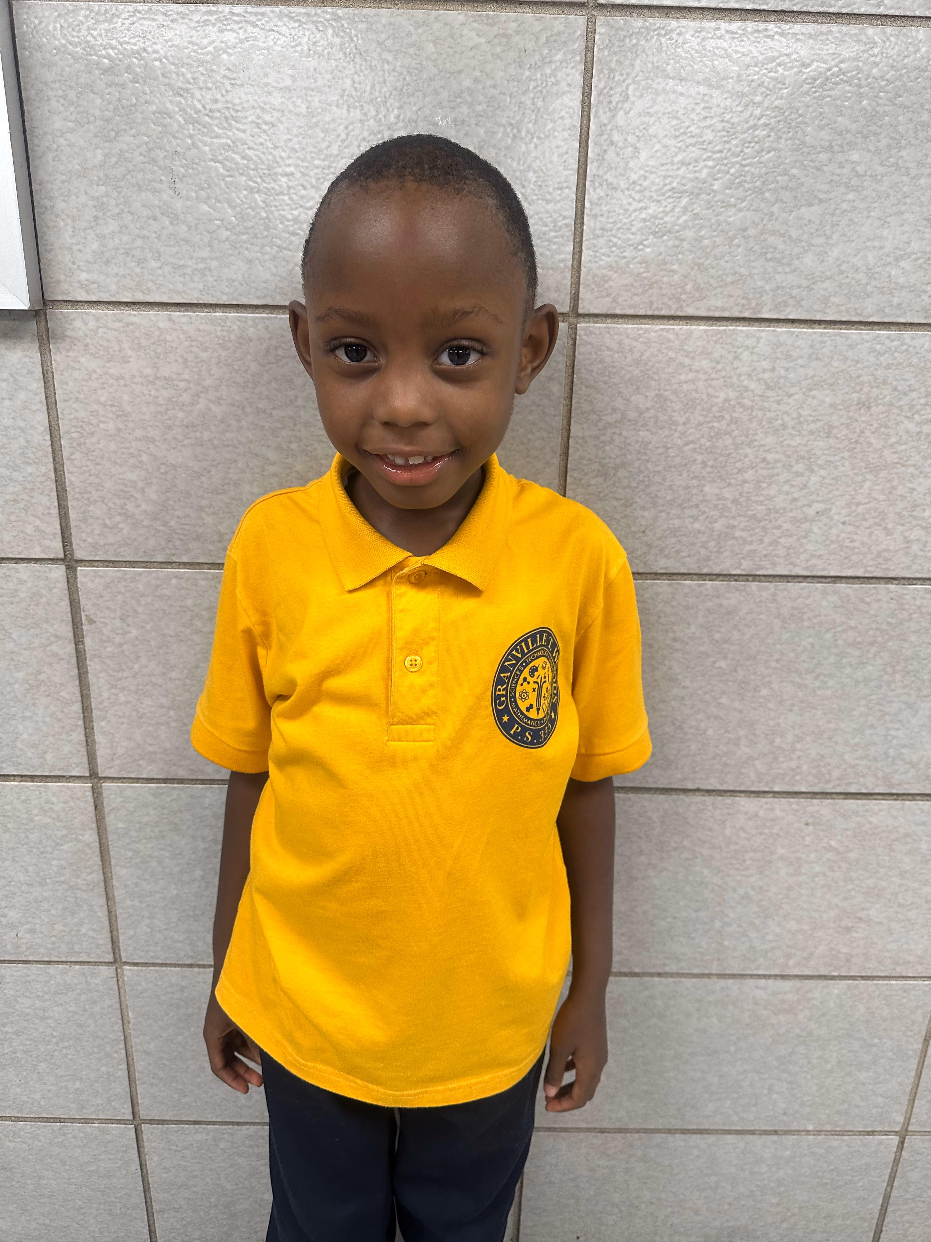 Student Alhaji Graham smiling in Granville P.S. yellow uniform polo