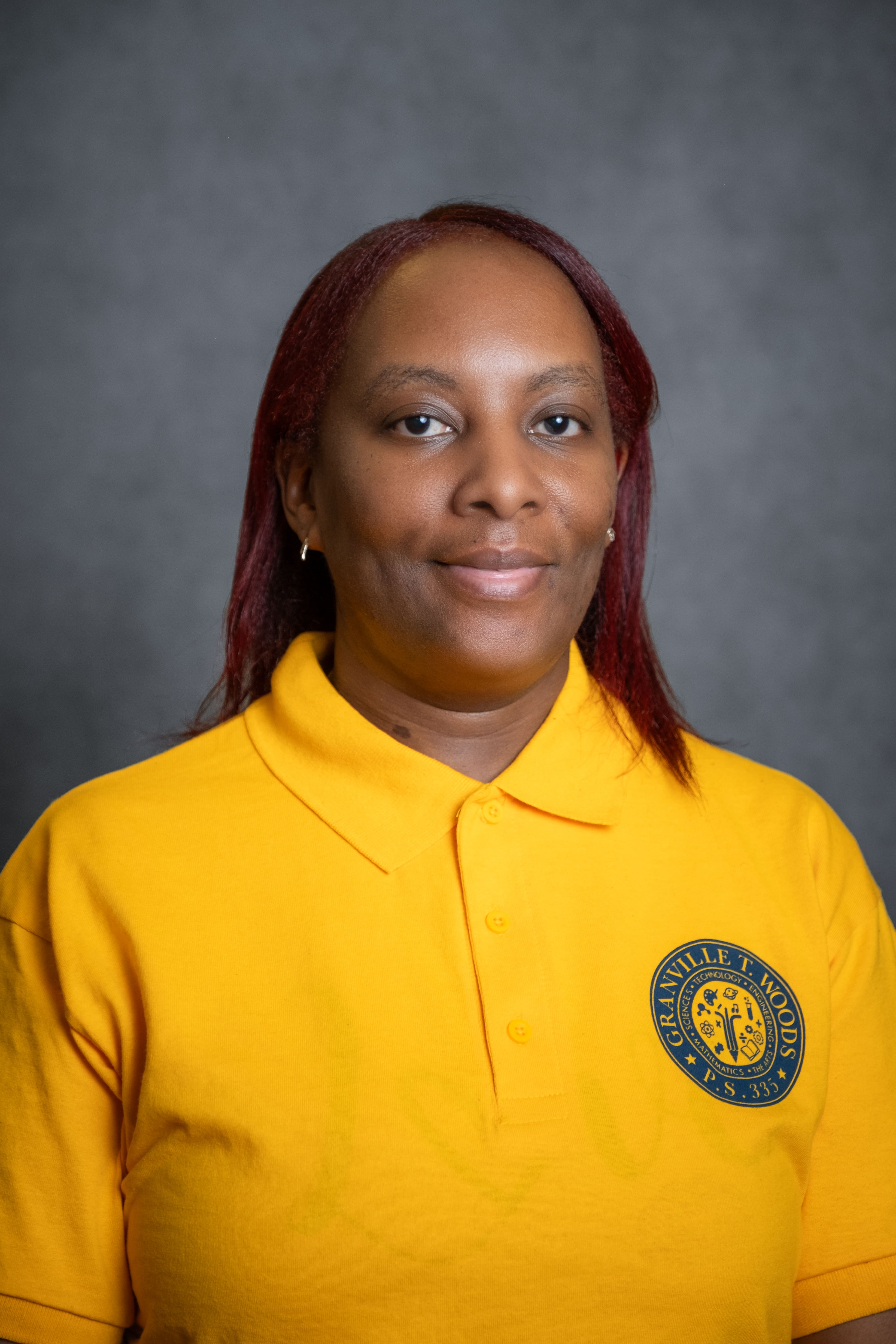 Staff member C. Bonnette wearing Granville T. Woods PS 333 polo shirt