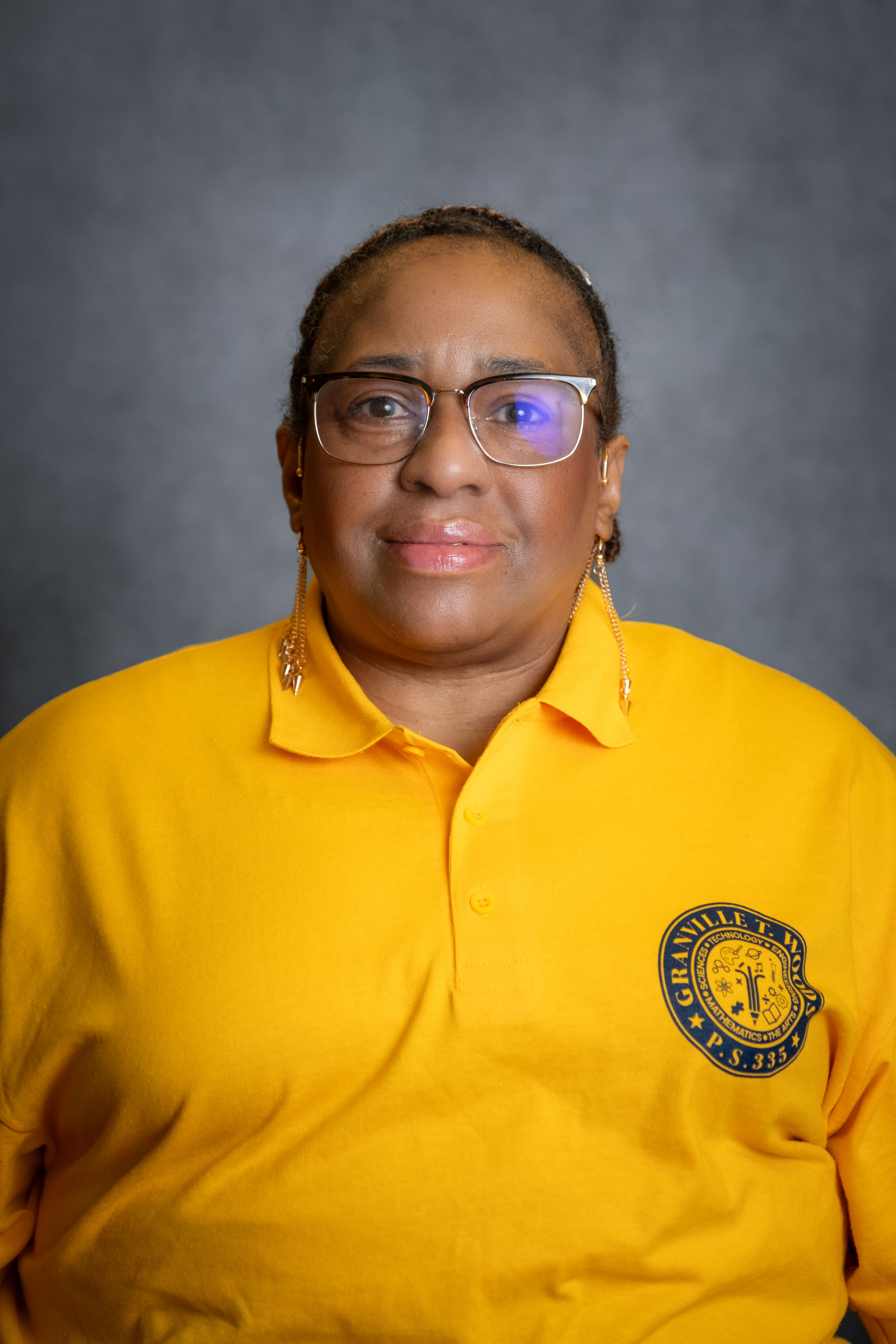 Staff member portrait wearing P.S. 335 yellow school polo shirt